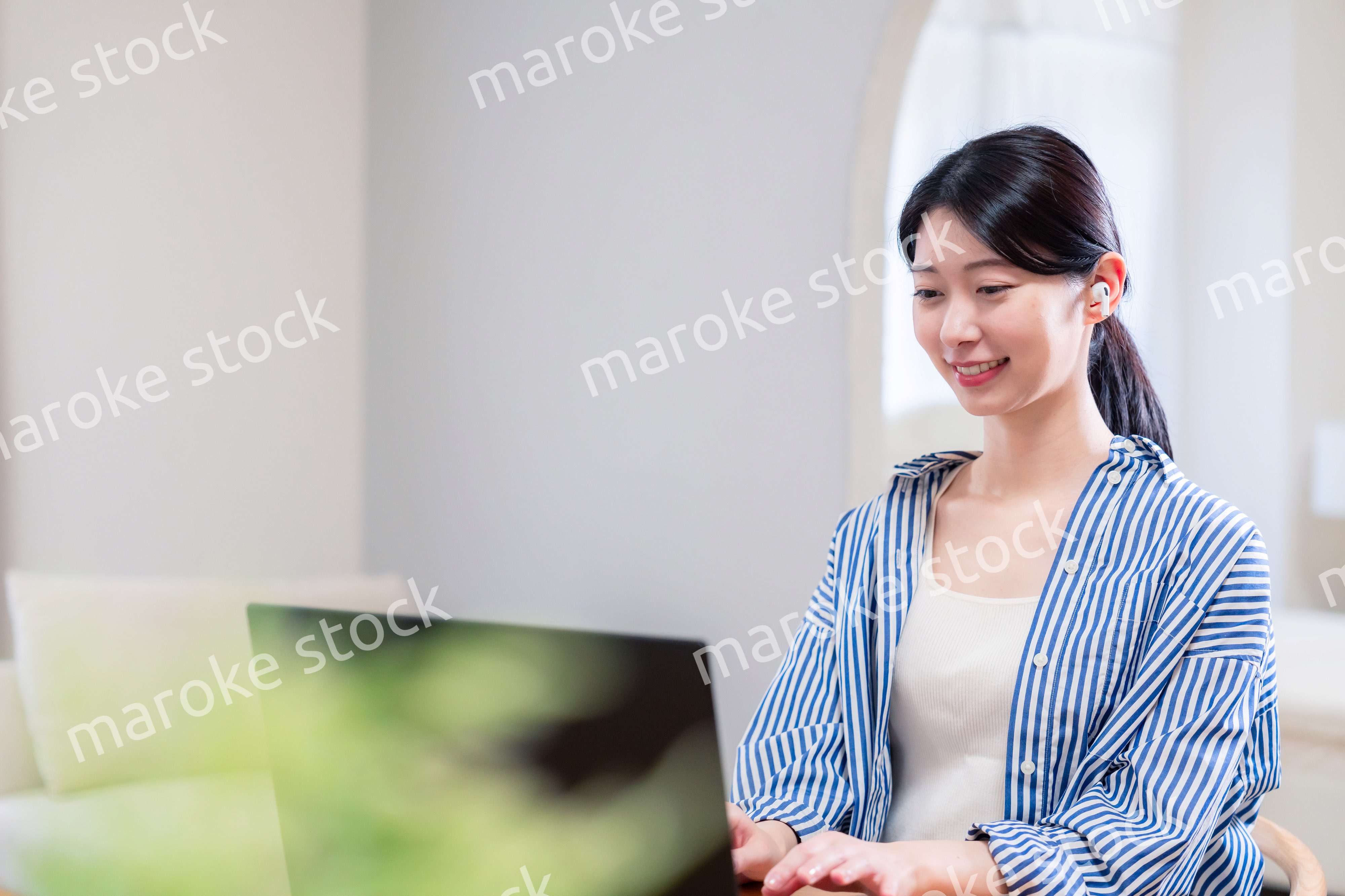 在宅でリモート会議に参加する若い女性社員