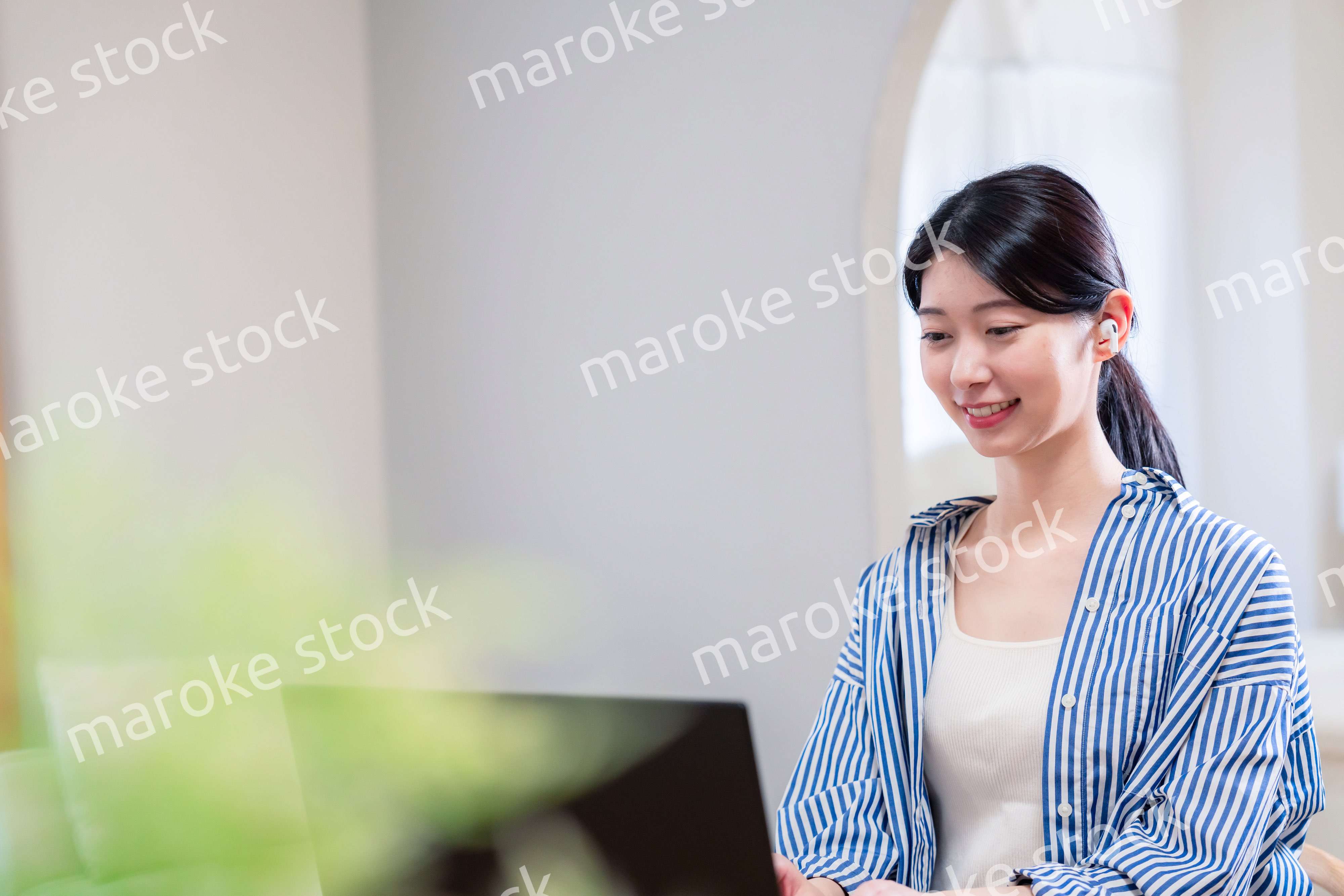 在宅でリモート会議に参加する若い女性社員