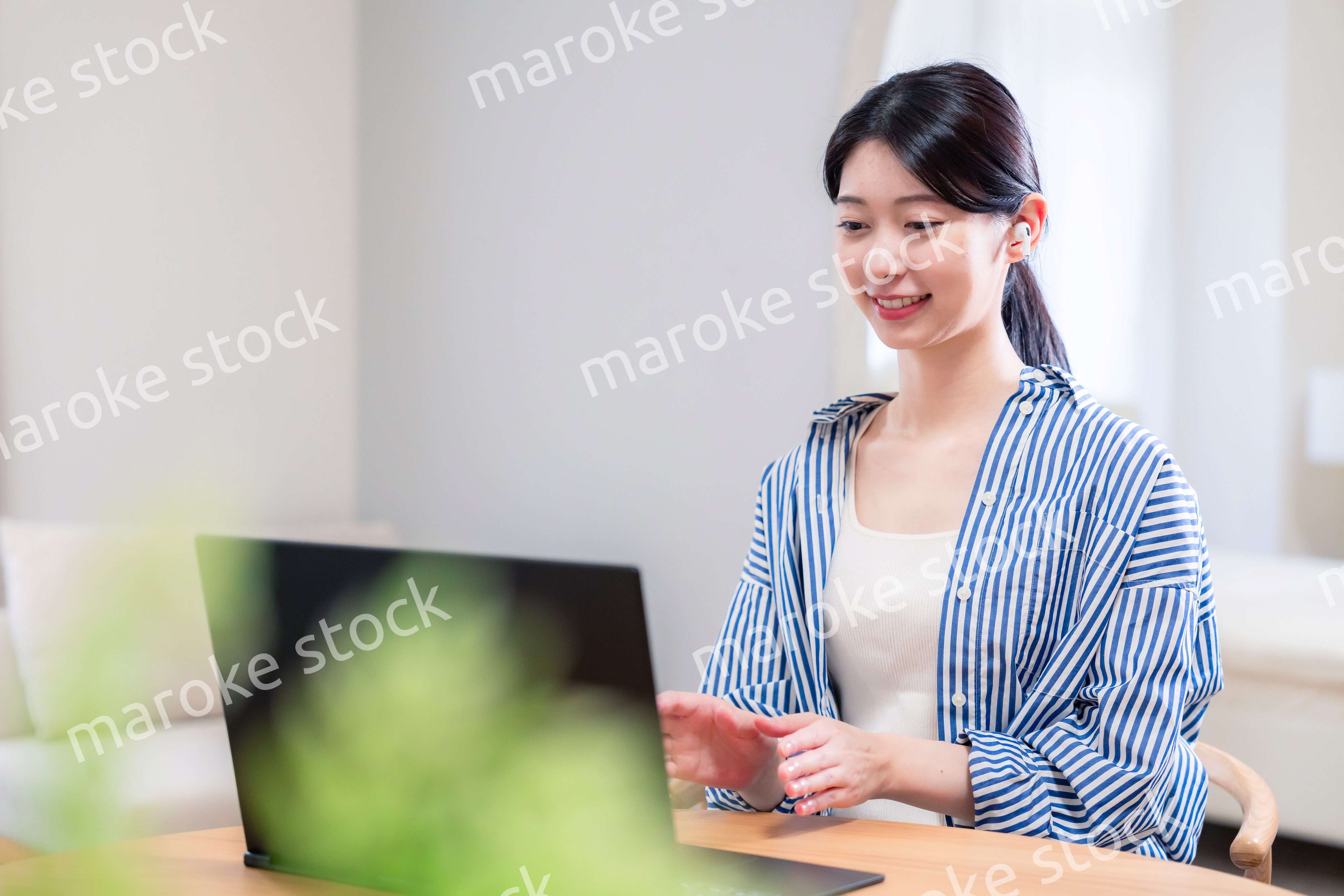 在宅でリモート会議に参加する若い女性社員