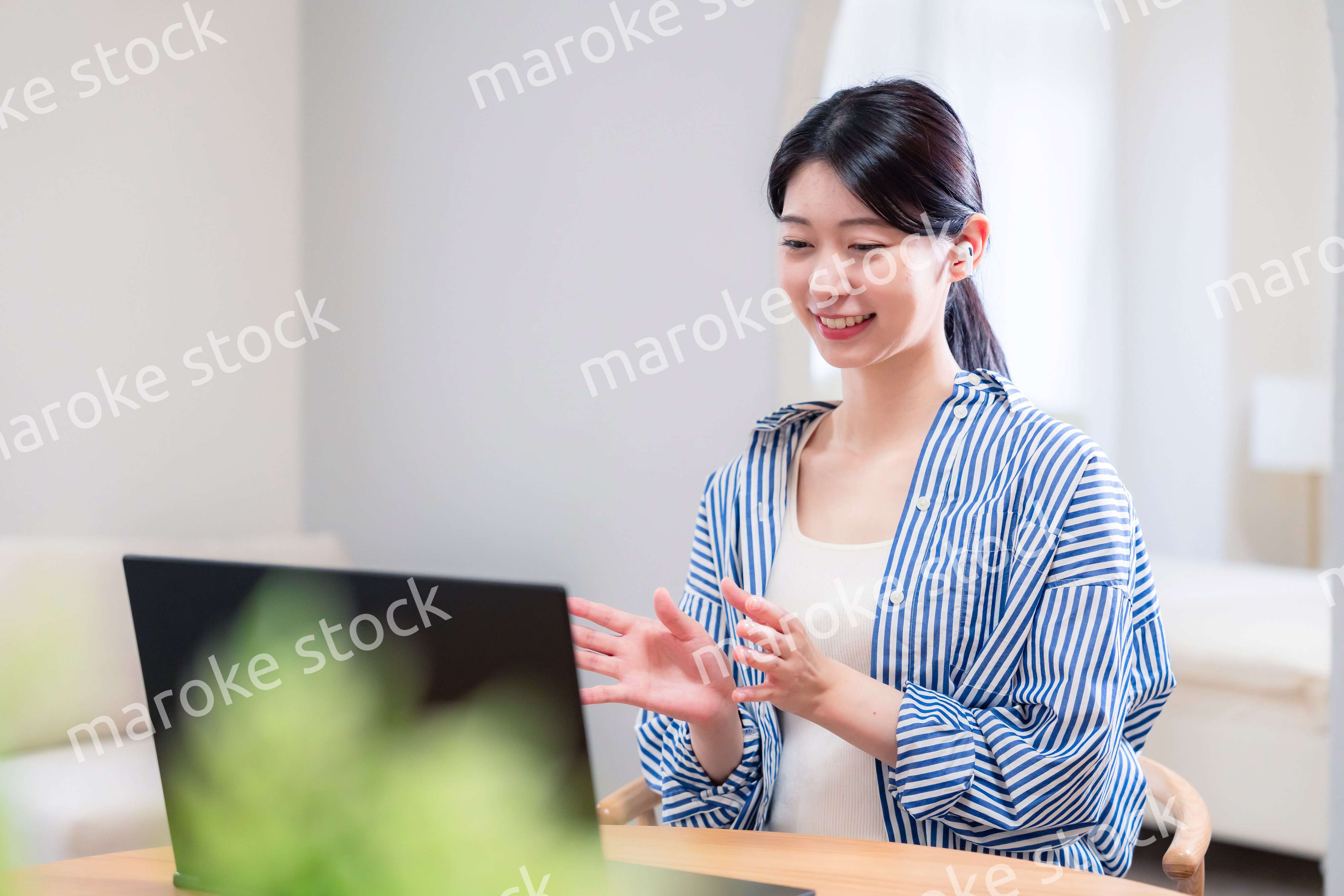 在宅でリモート会議に参加する若い女性社員