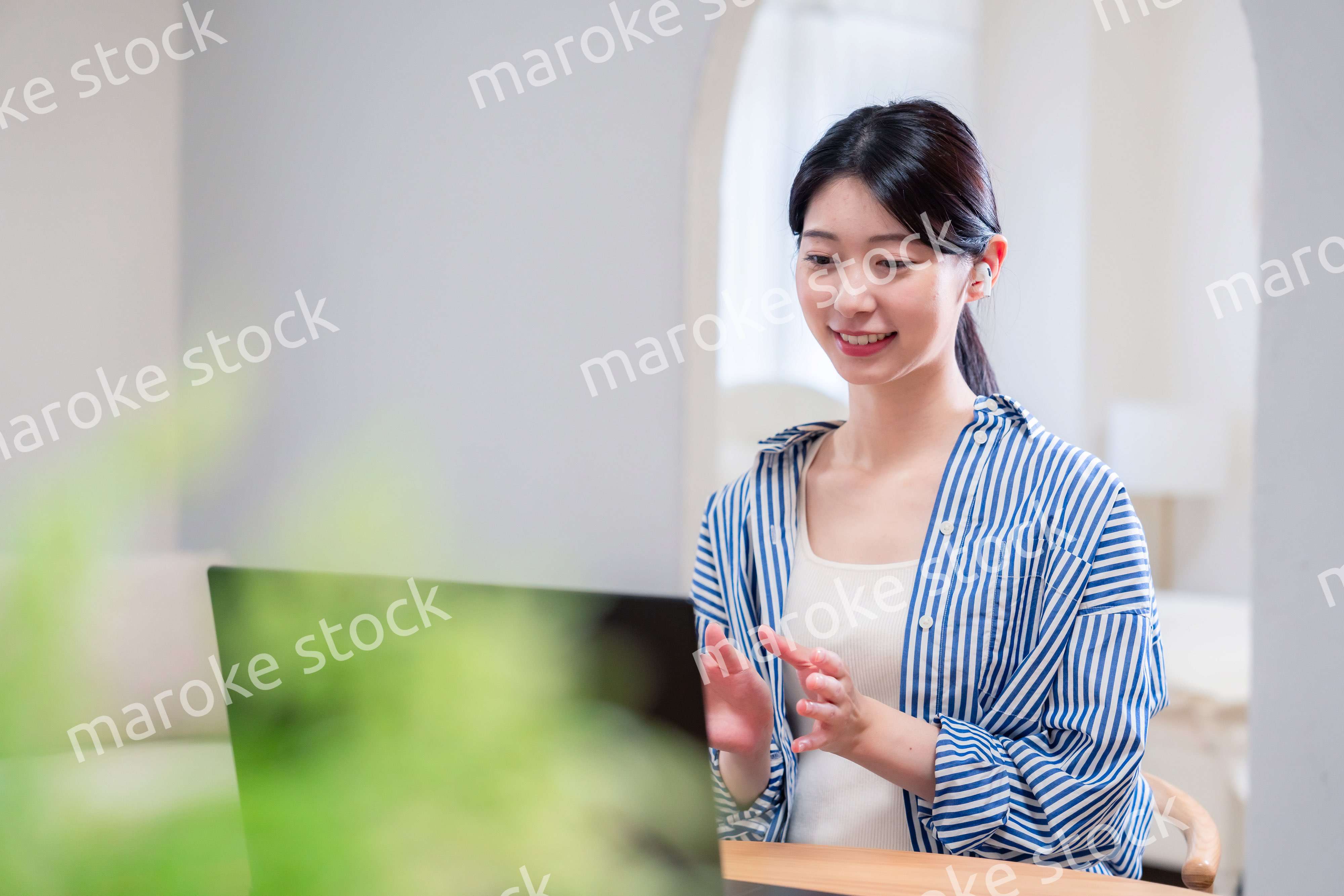 在宅でリモート会議に参加する若い女性社員