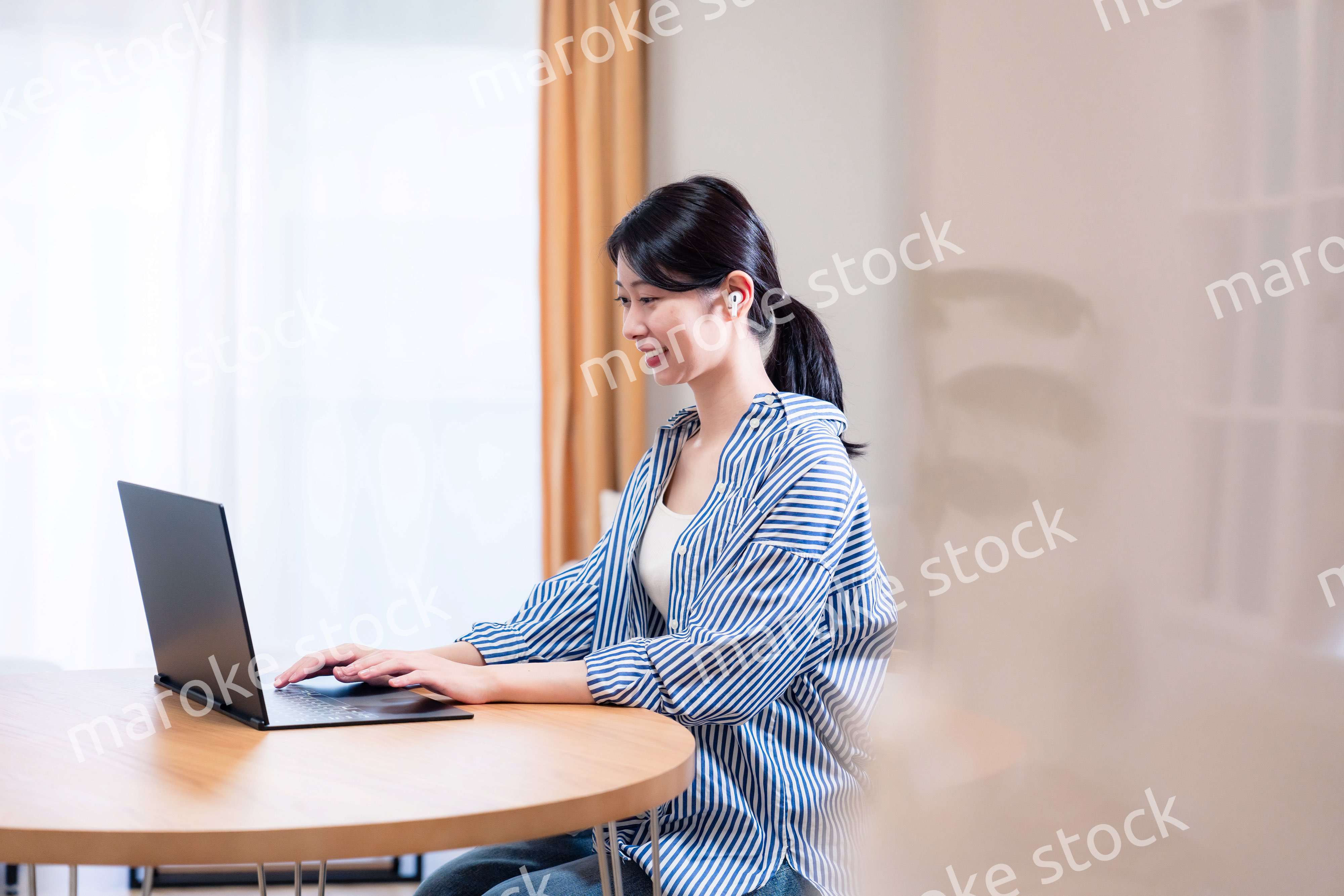 在宅でリモート会議に参加する若い女性社員