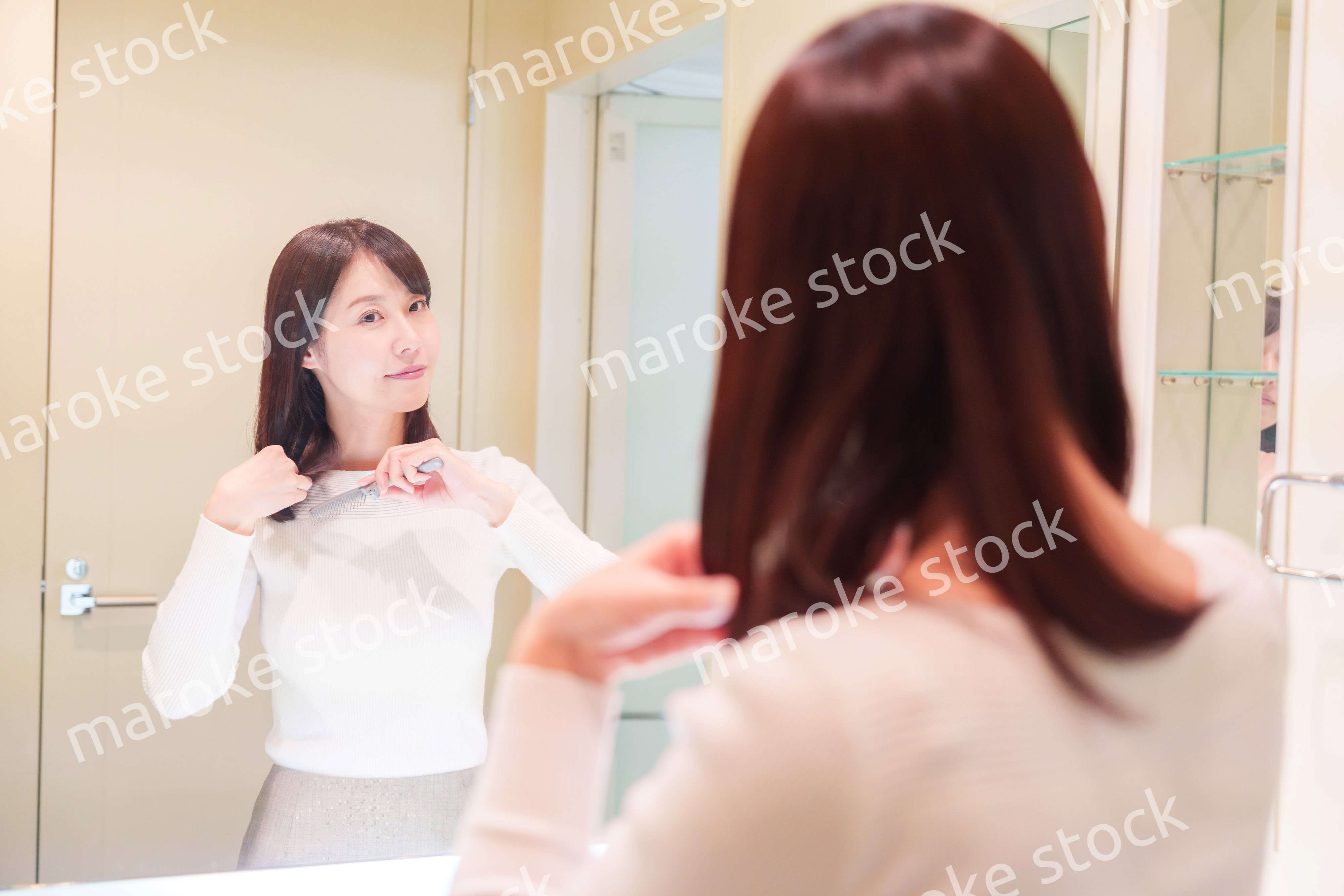 お出かけ前に身だしなみを整えるミドルシニアの女性