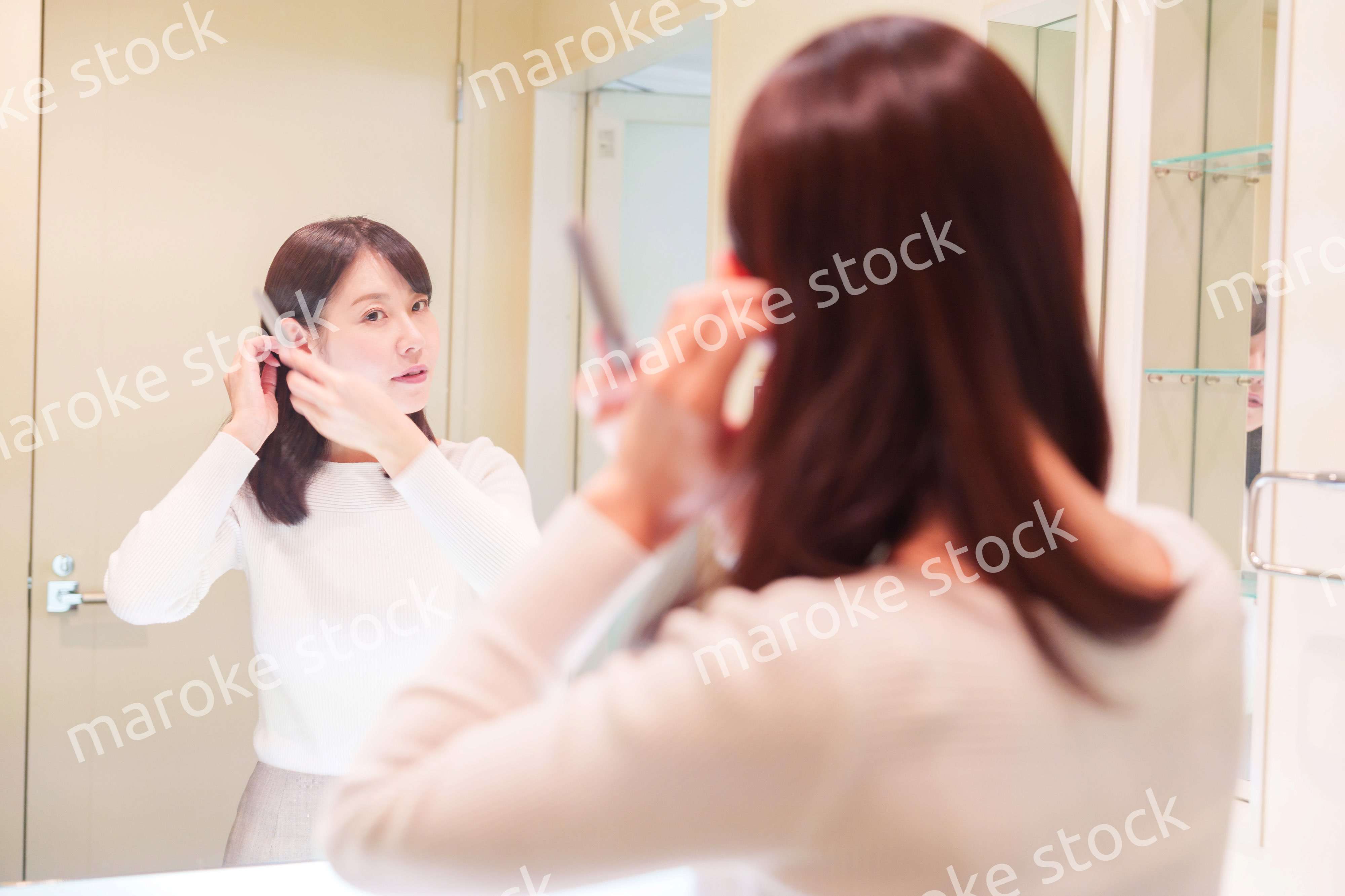 お出かけ前に身だしなみを整えるミドルシニアの女性