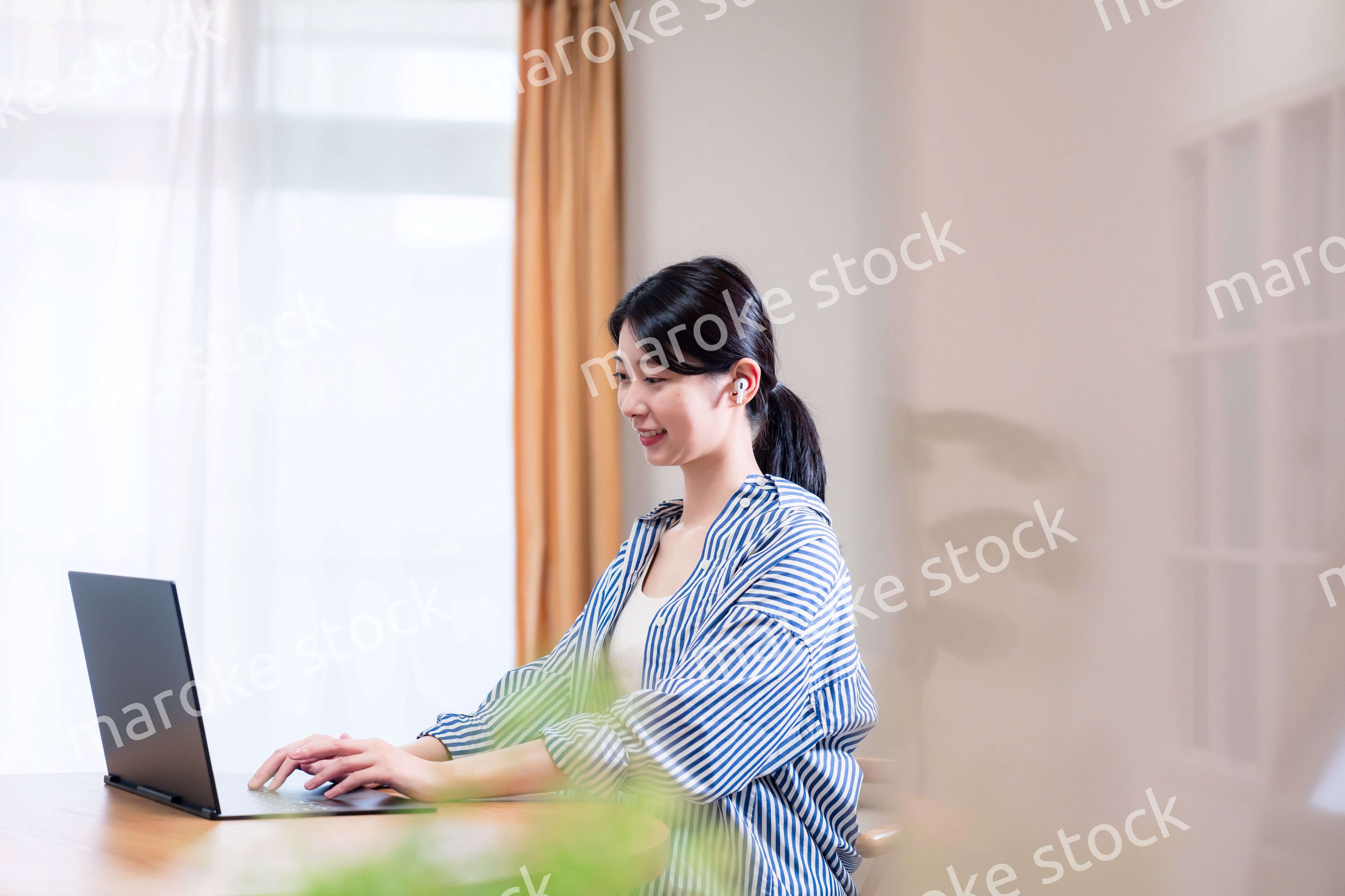 在宅でリモート会議に参加する若い女性社員