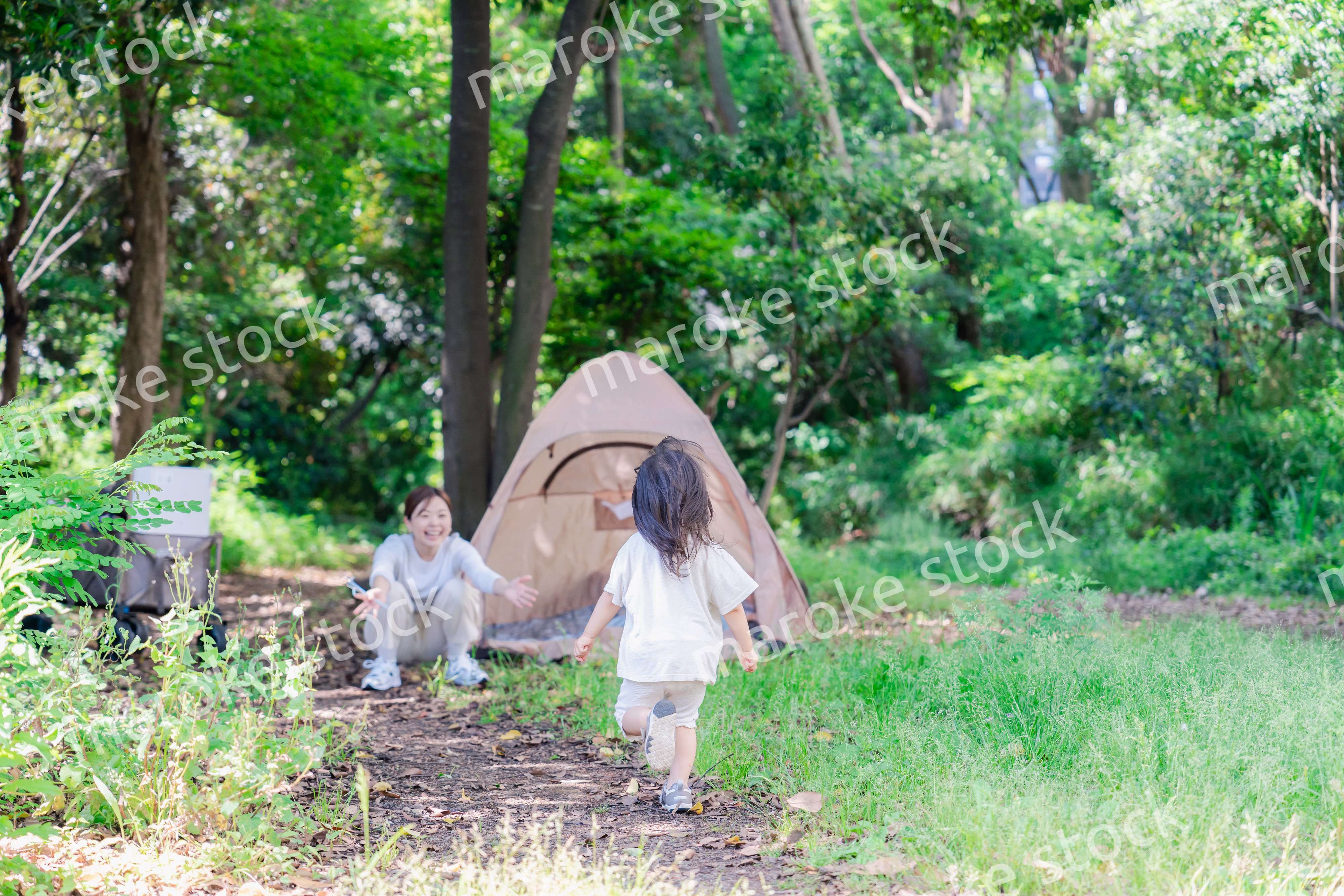 森の中でかけっこをする子どもとお母さん