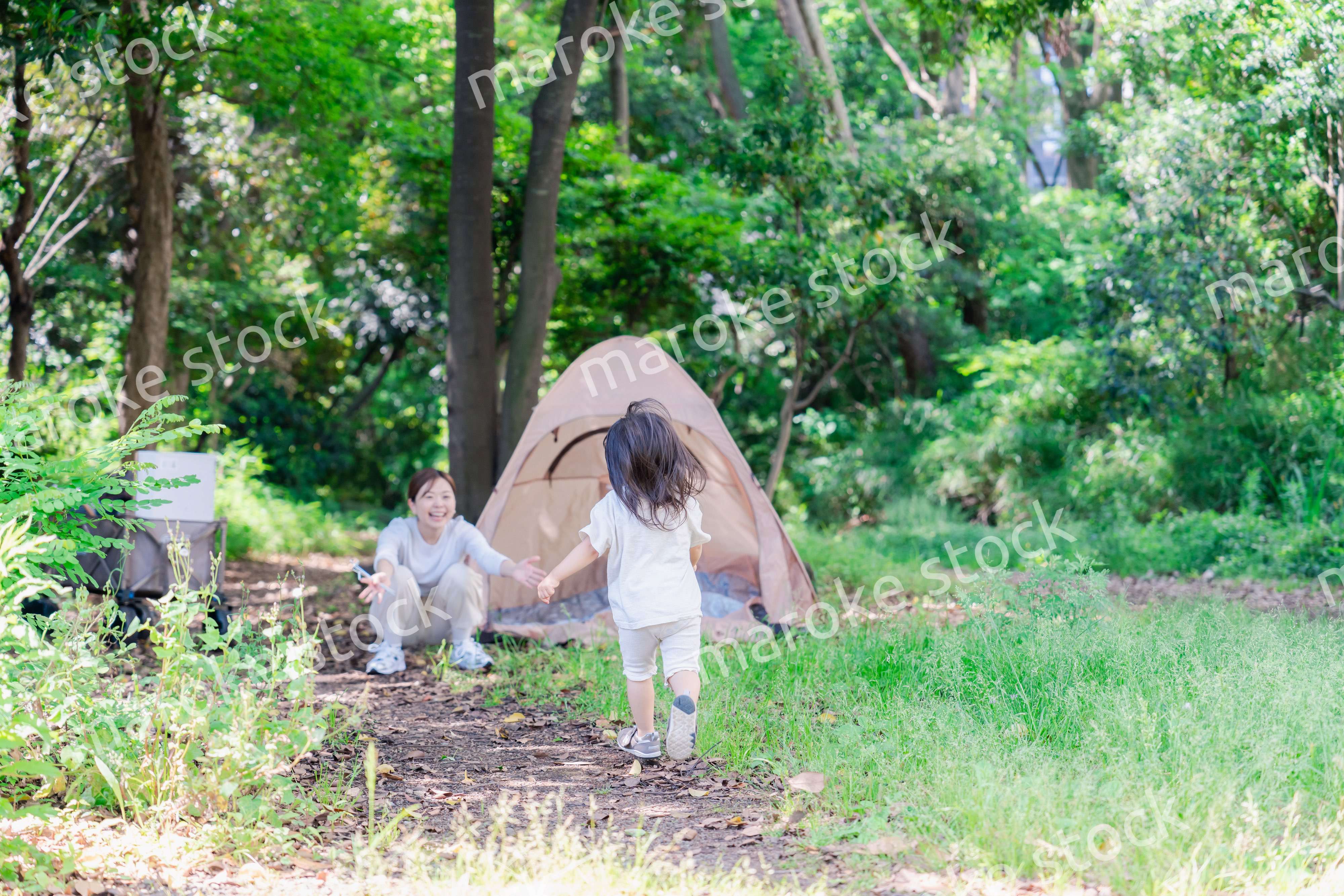 森の中でかけっこをする子どもとお母さん
