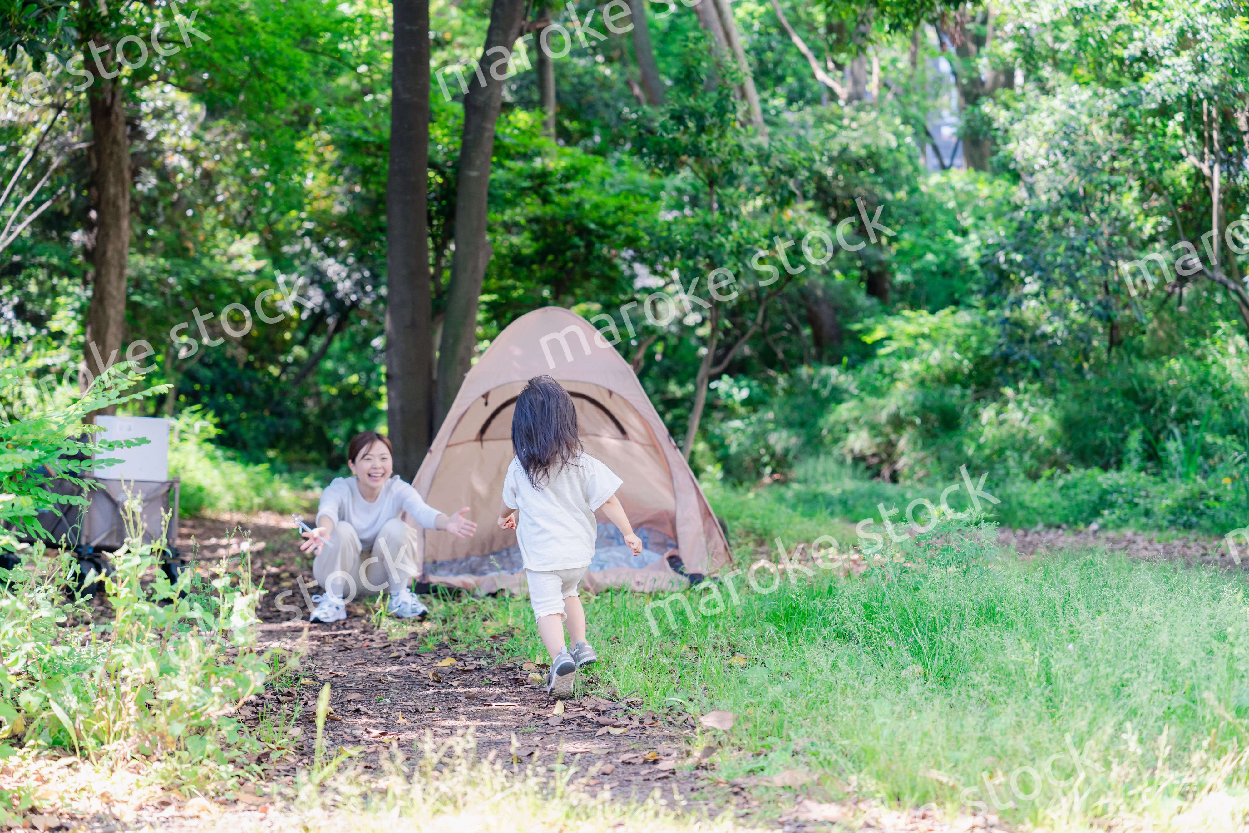 森の中でかけっこをする子どもとお母さん