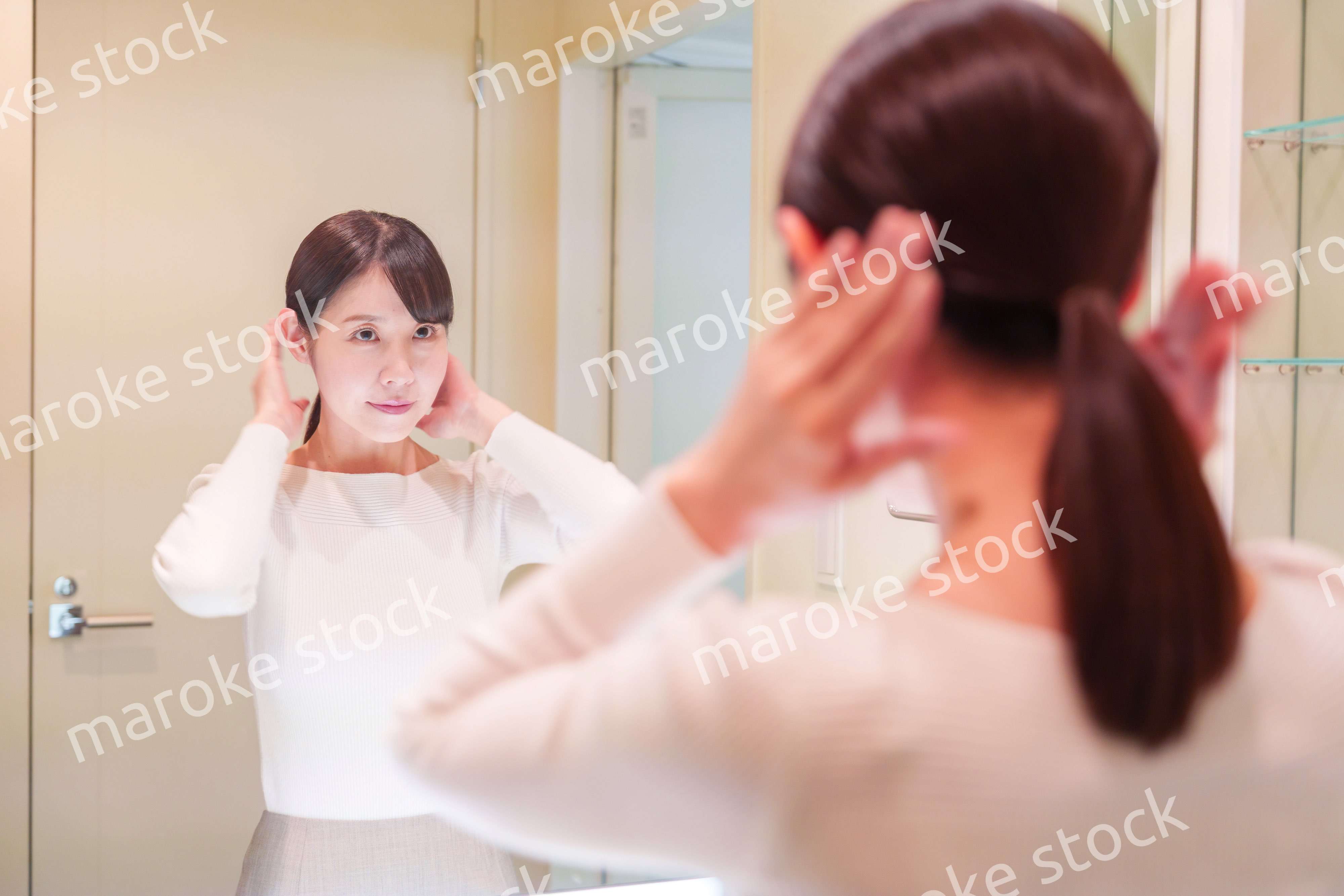 お出かけ前に身だしなみを整えるミドルシニアの女性