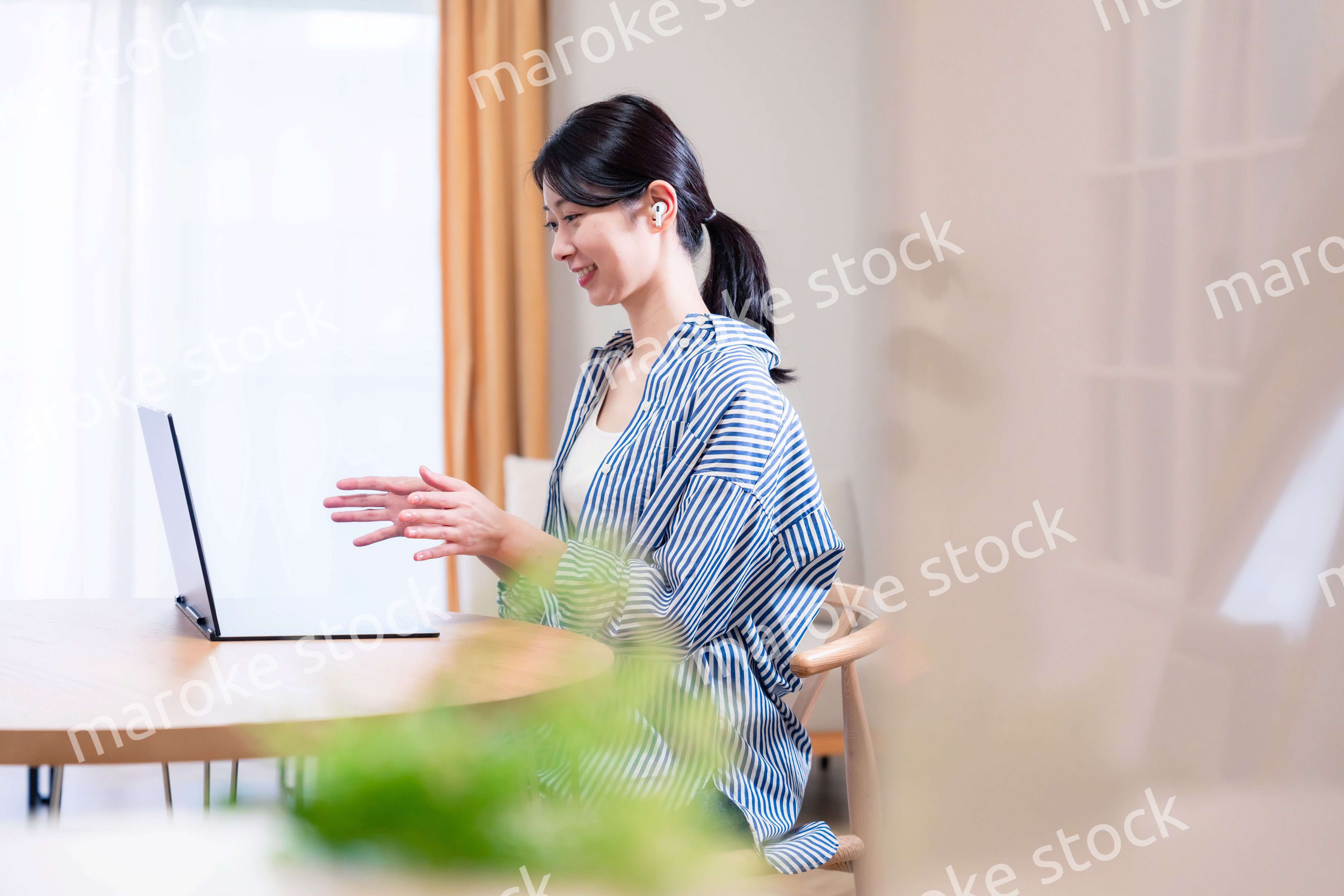 在宅でリモート会議に参加する若い女性社員