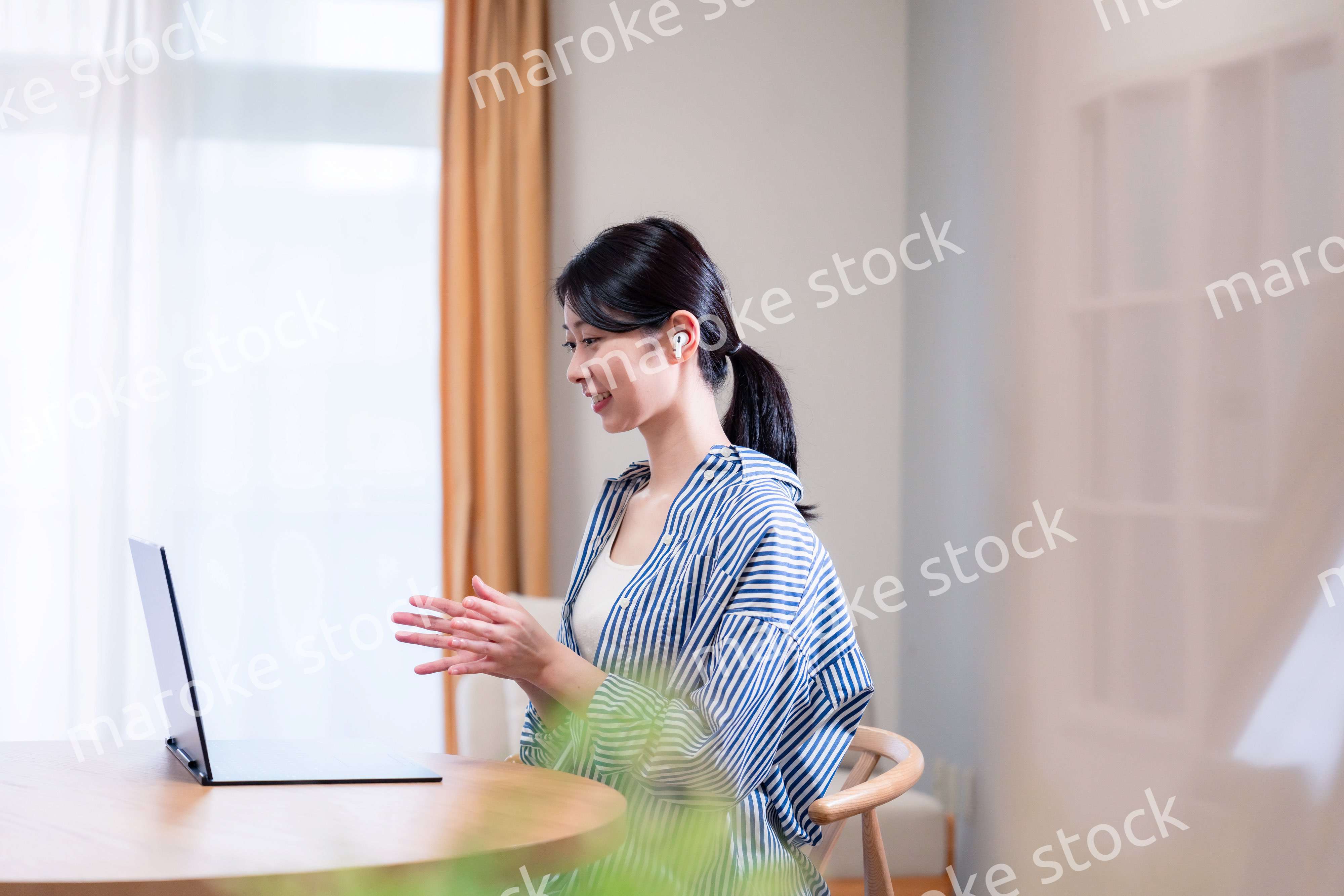 在宅でリモート会議に参加する若い女性社員