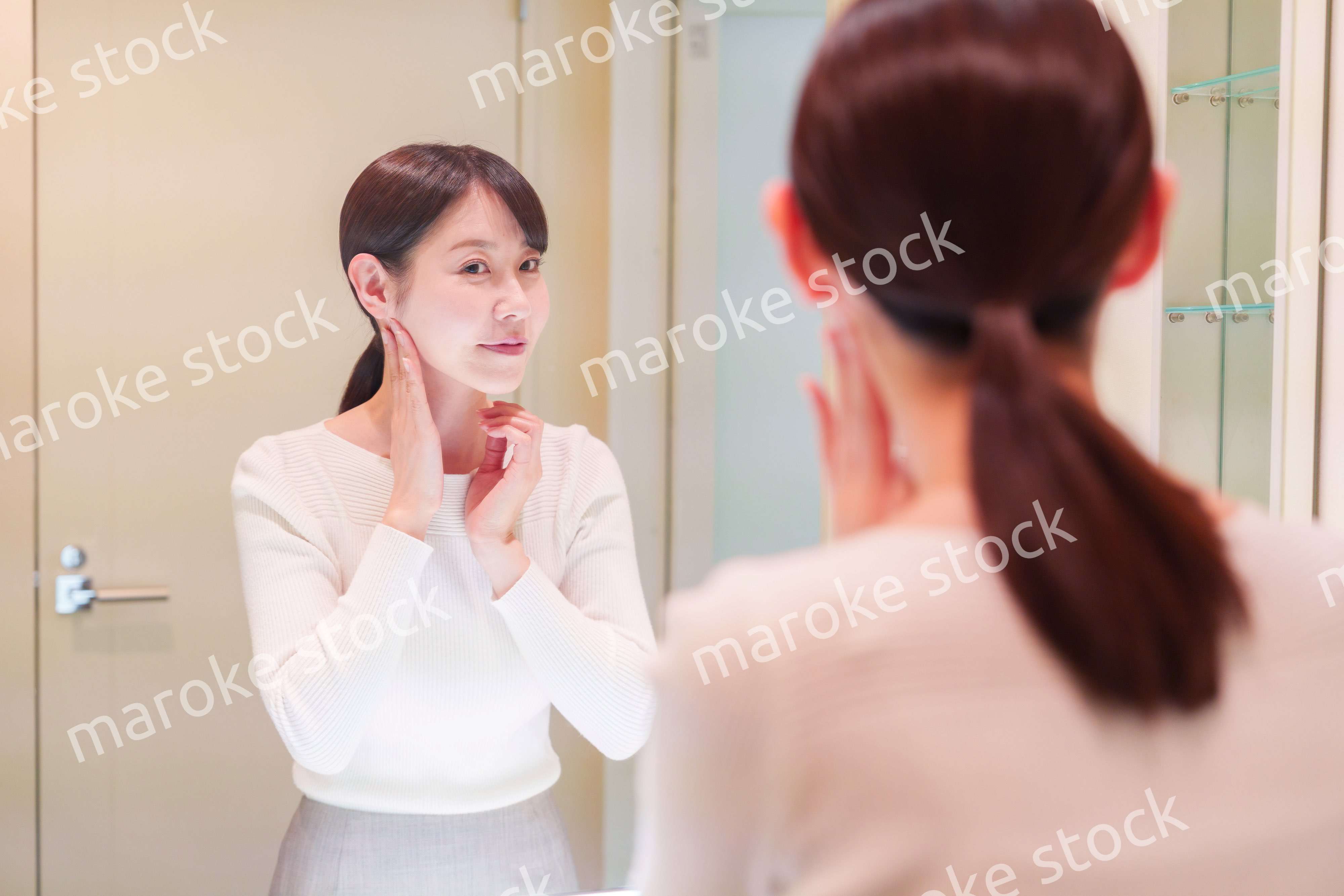 お出かけ前に身だしなみを整えるミドルシニアの女性