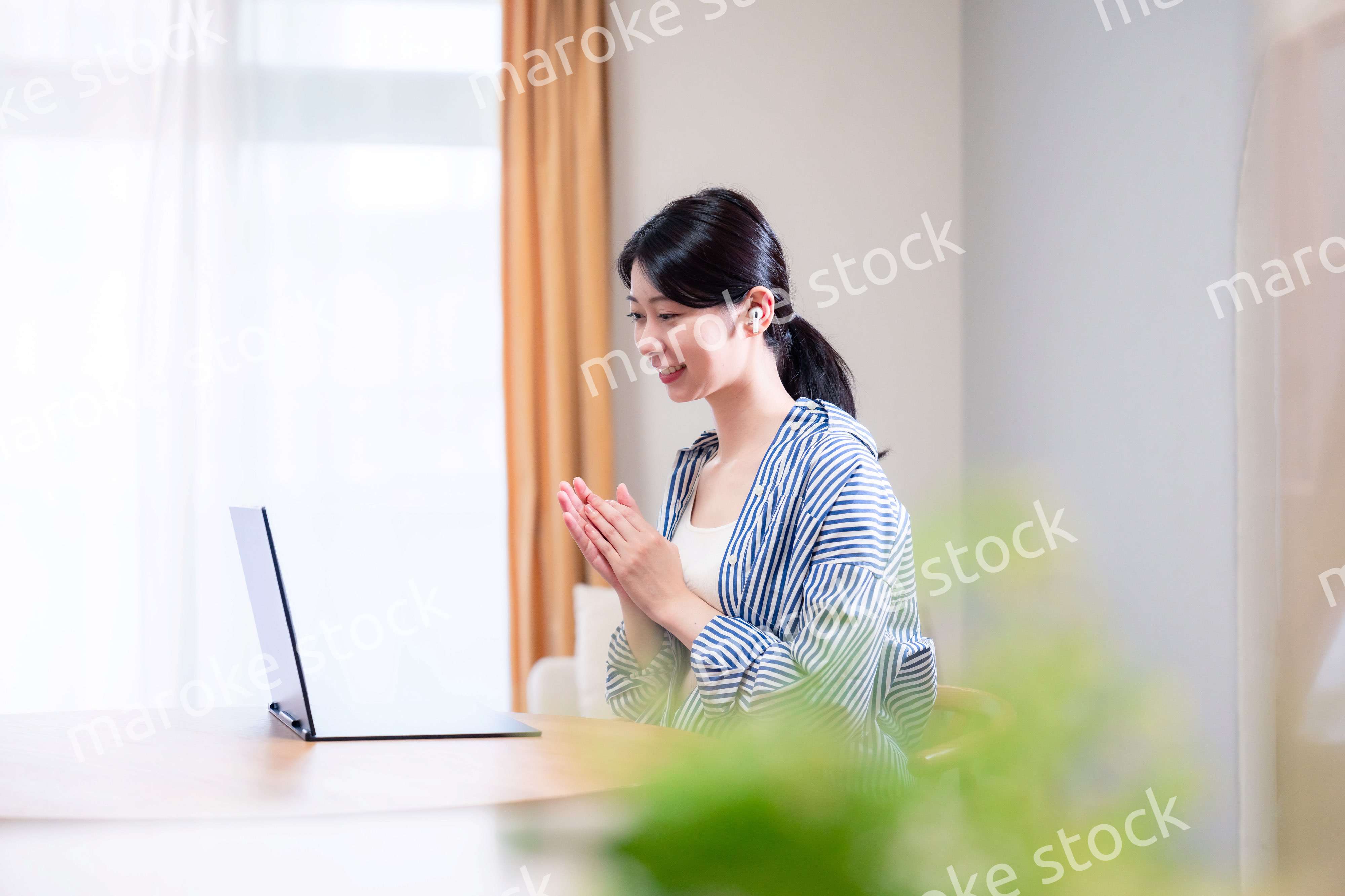 在宅でリモート会議に参加する若い女性社員