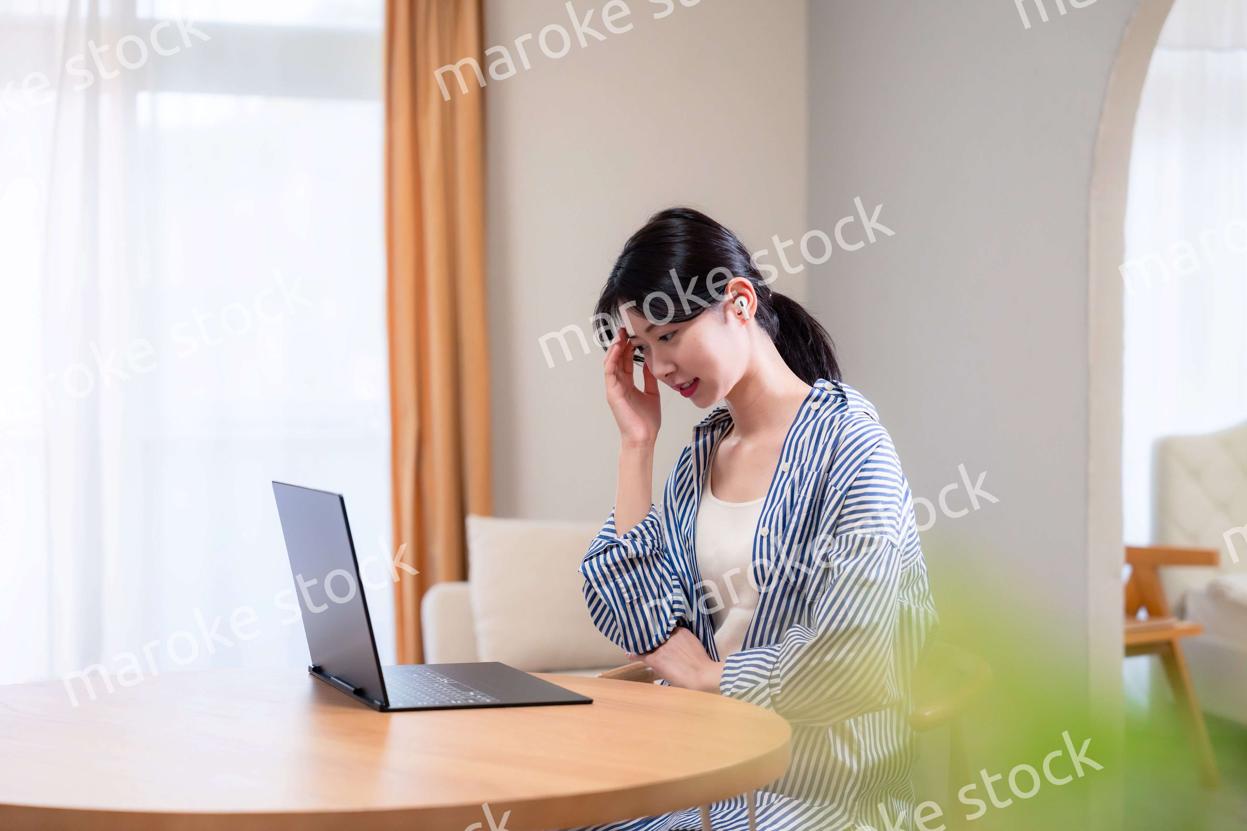 在宅勤務をしながら頭を抱える若い女性