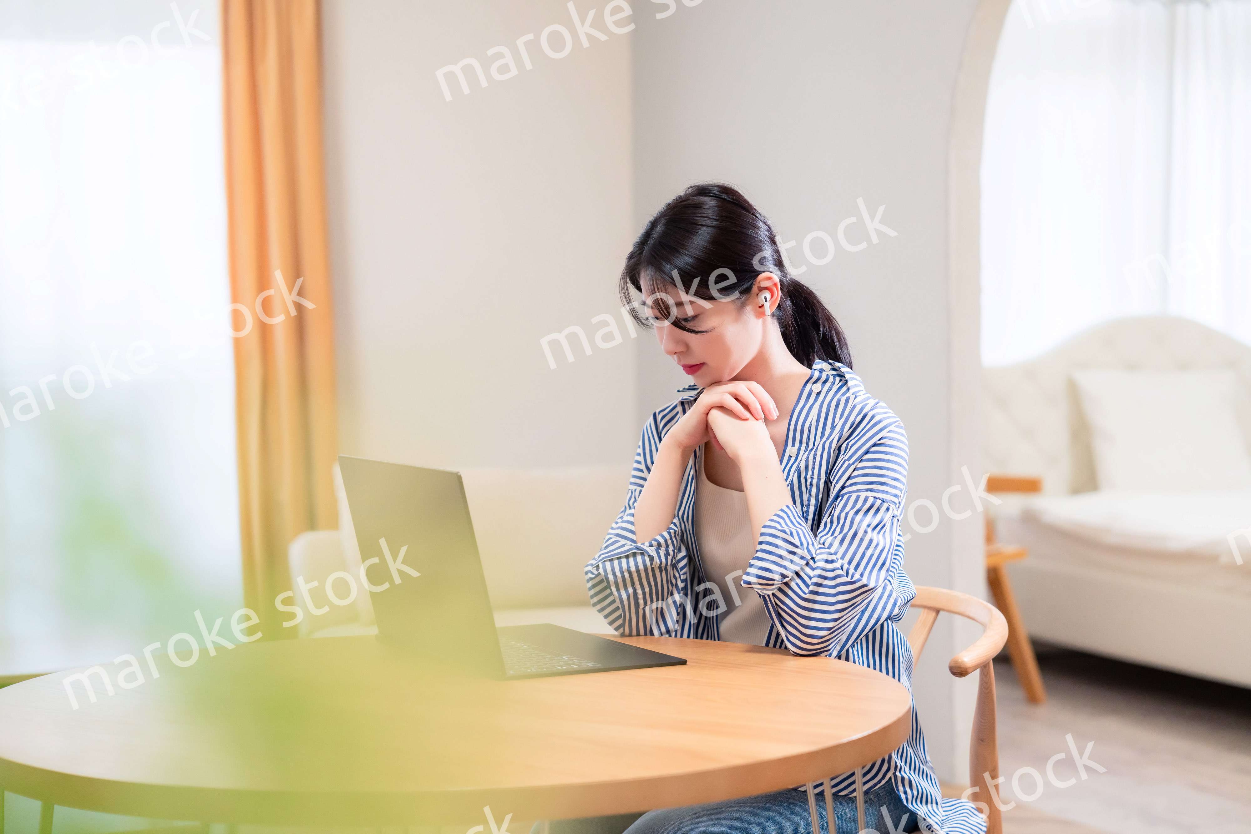 在宅勤務をしながら頭を抱える若い女性