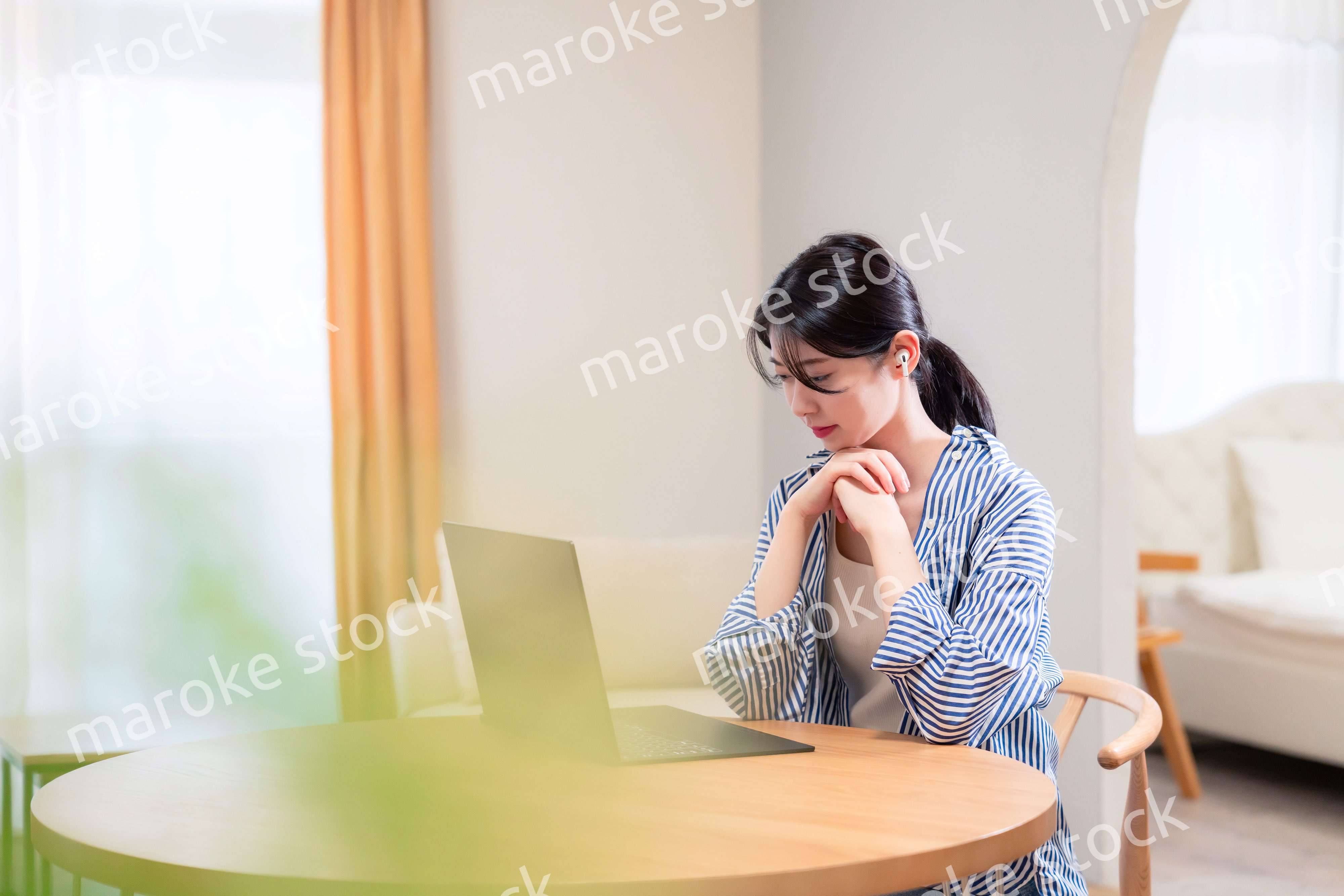 在宅勤務をしながら頭を抱える若い女性