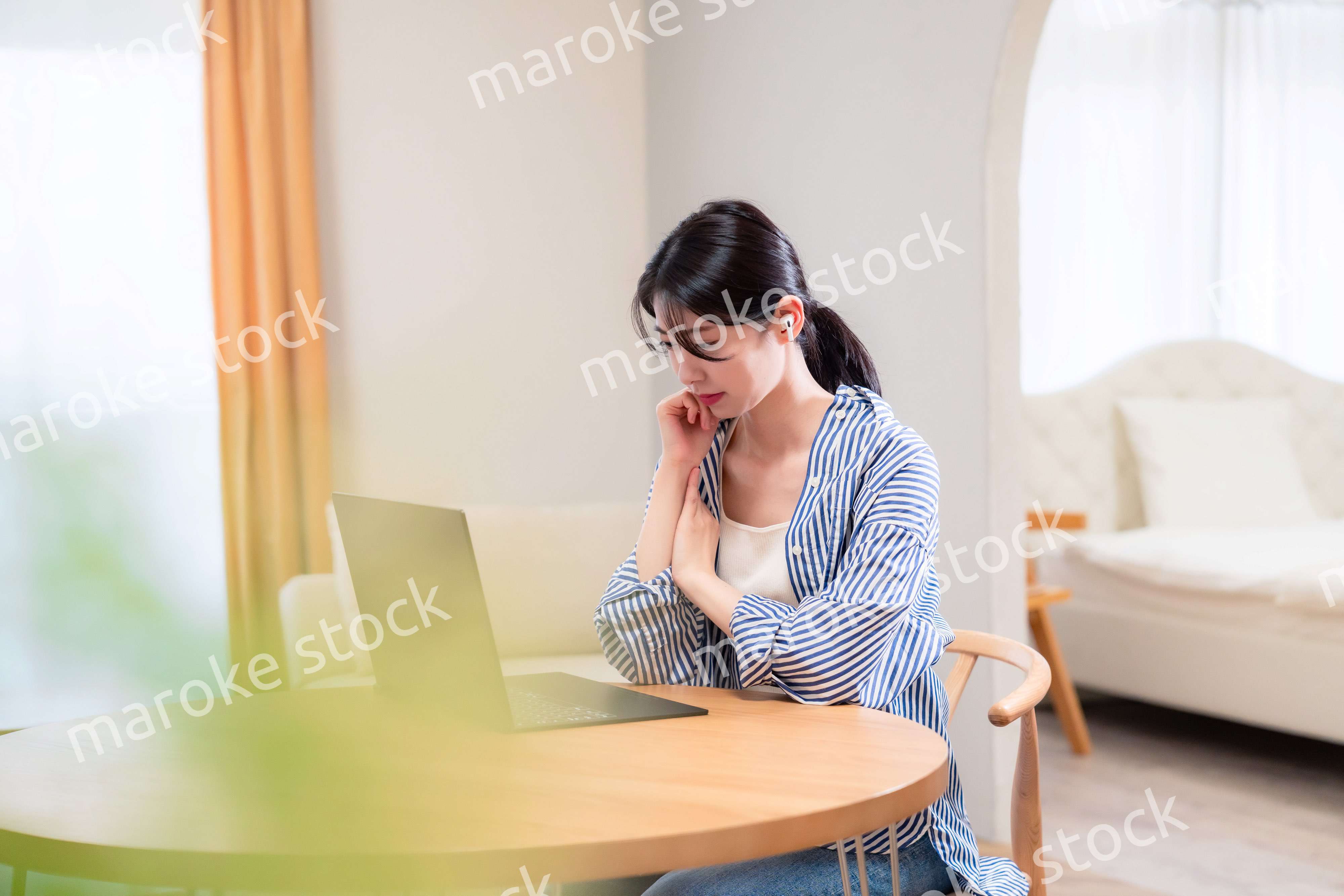 在宅勤務をしながら頭を抱える若い女性