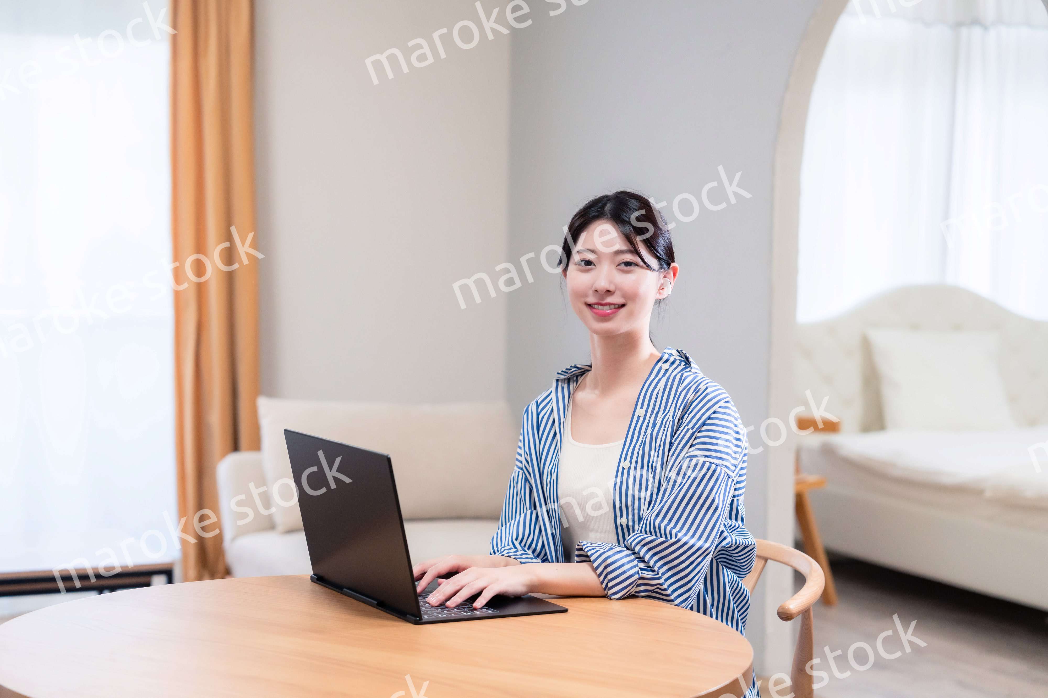 自宅で笑顔でリモート会議に参加する若い女性