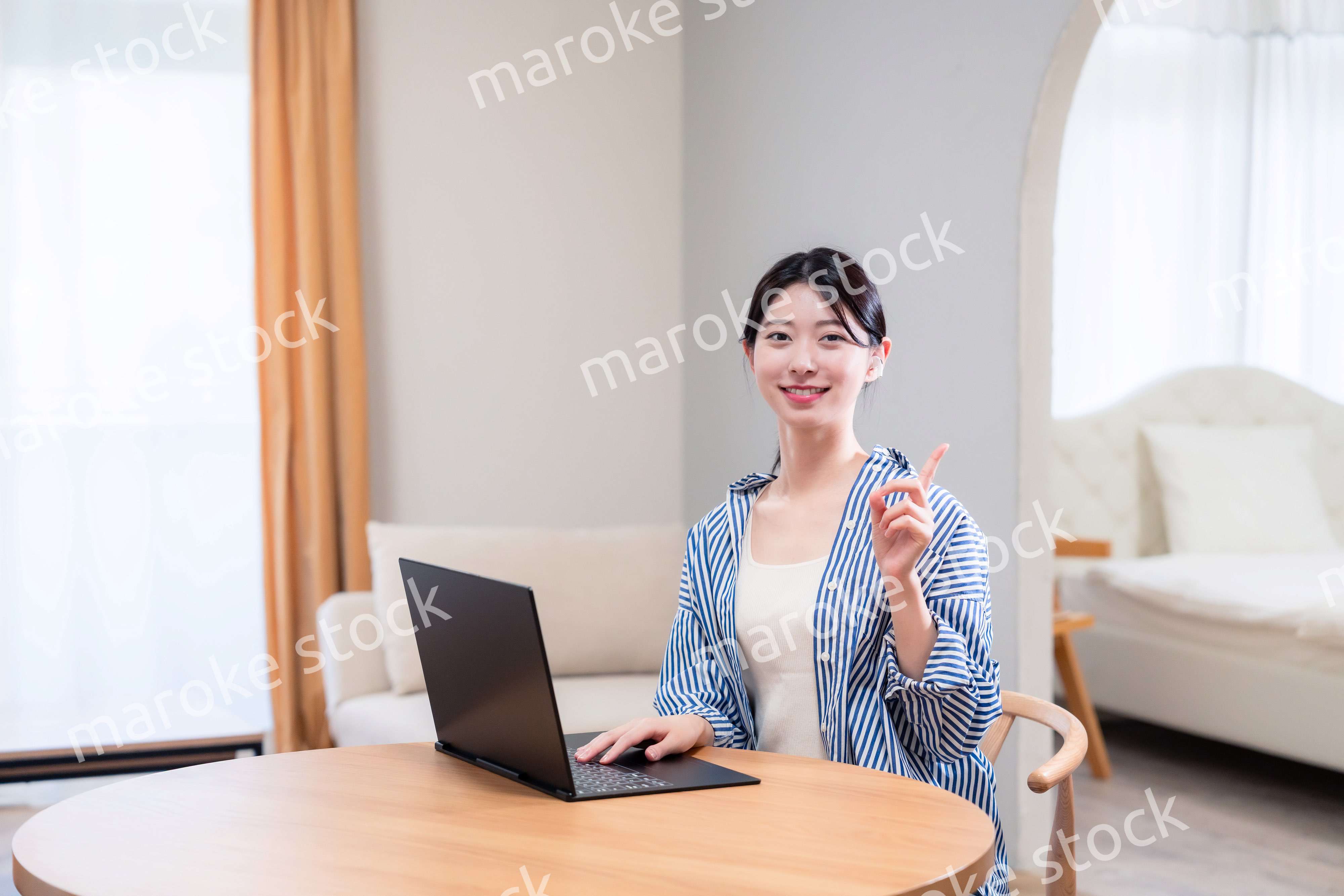 自宅で笑顔でリモート会議に参加する若い女性