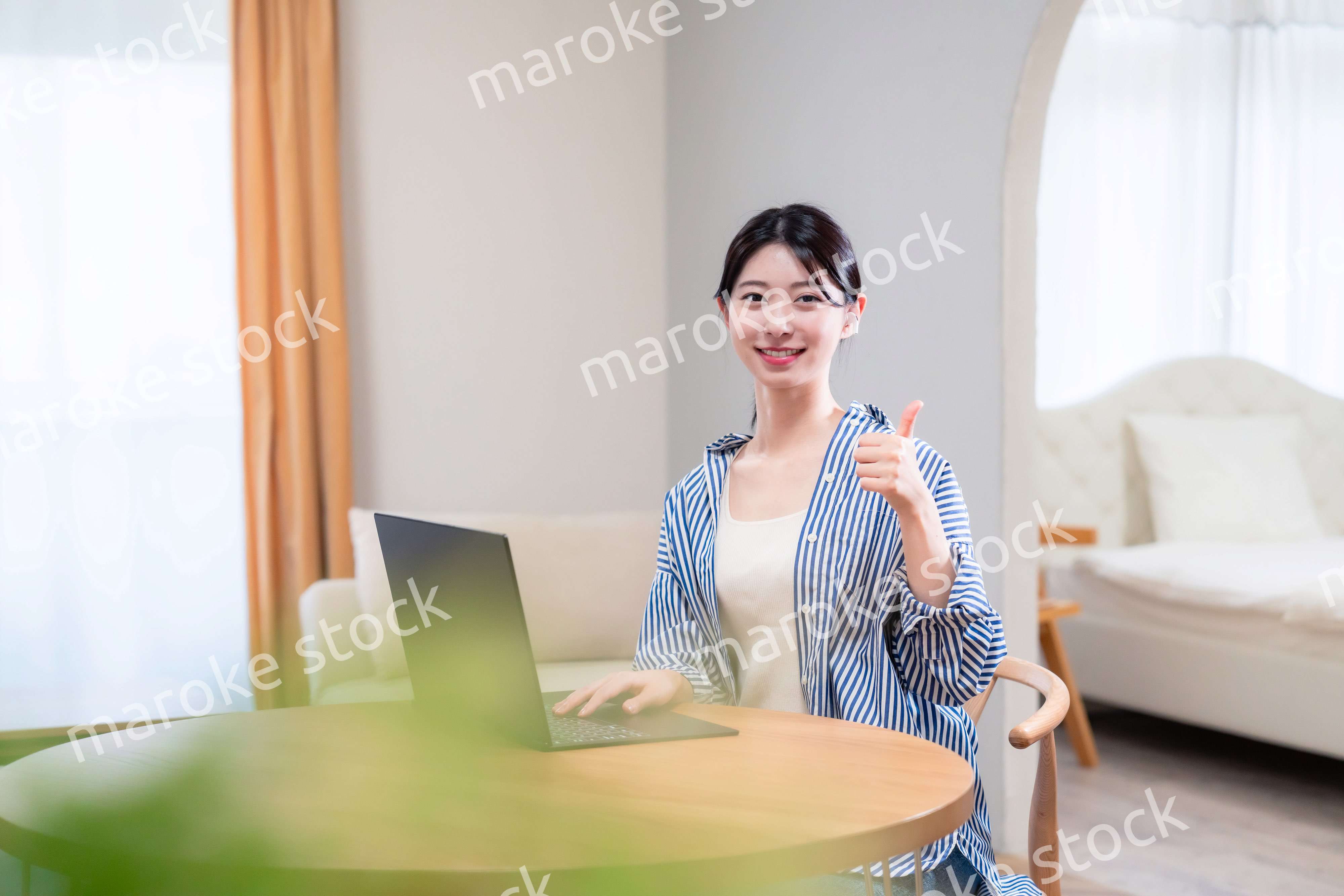 自宅で笑顔でリモート会議に参加する若い女性