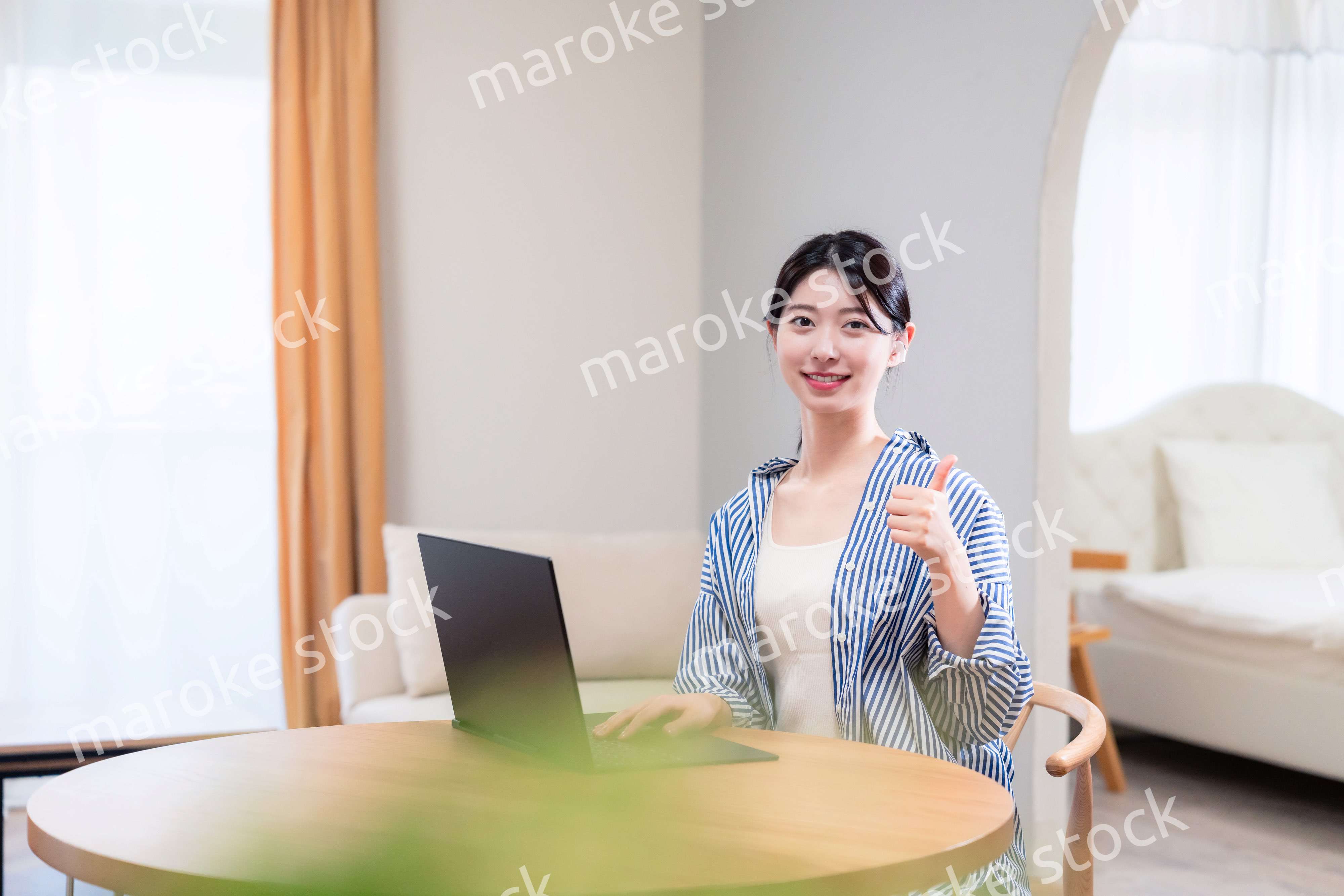 自宅で笑顔でリモート会議に参加する若い女性