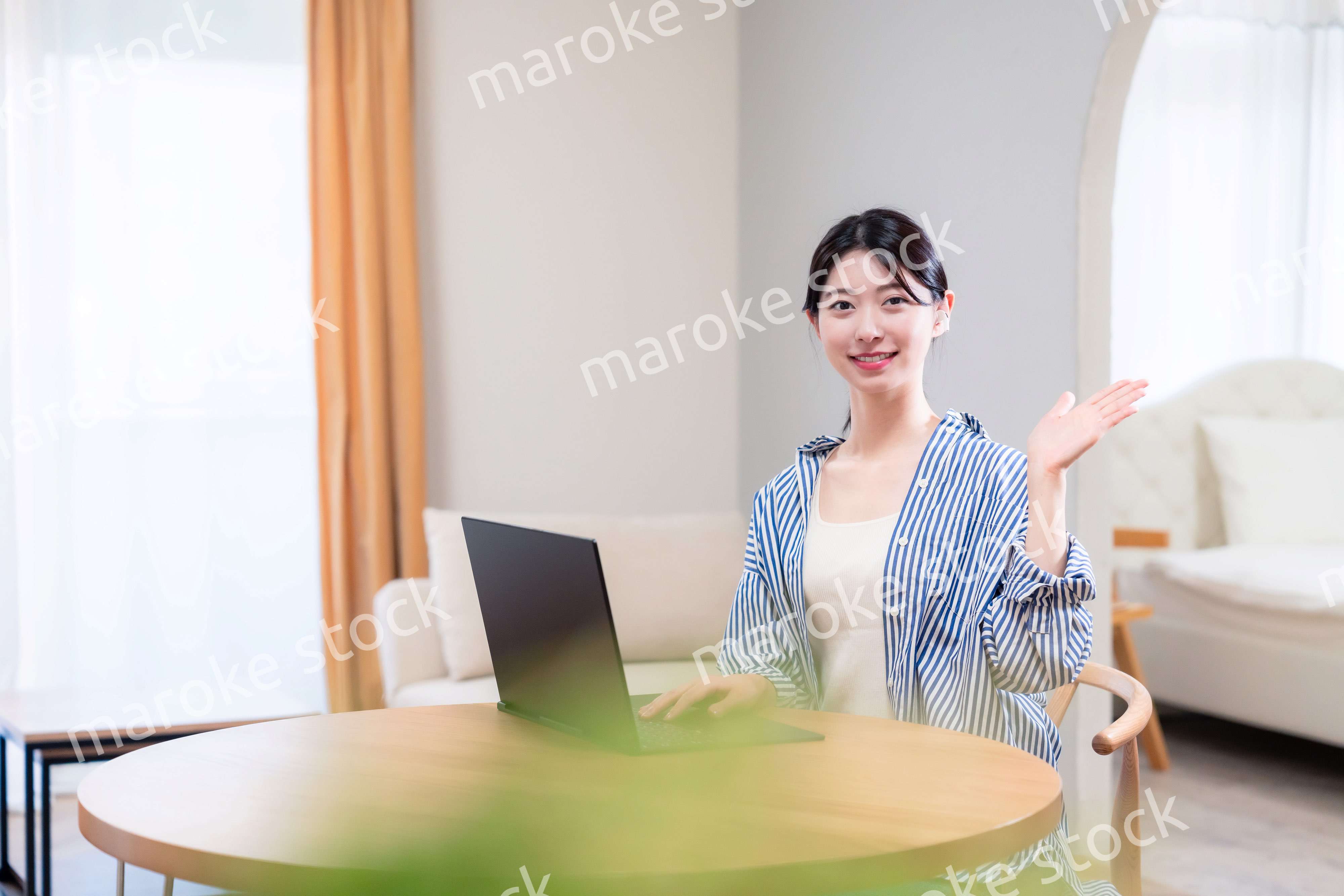 自宅で笑顔でリモート会議に参加する若い女性