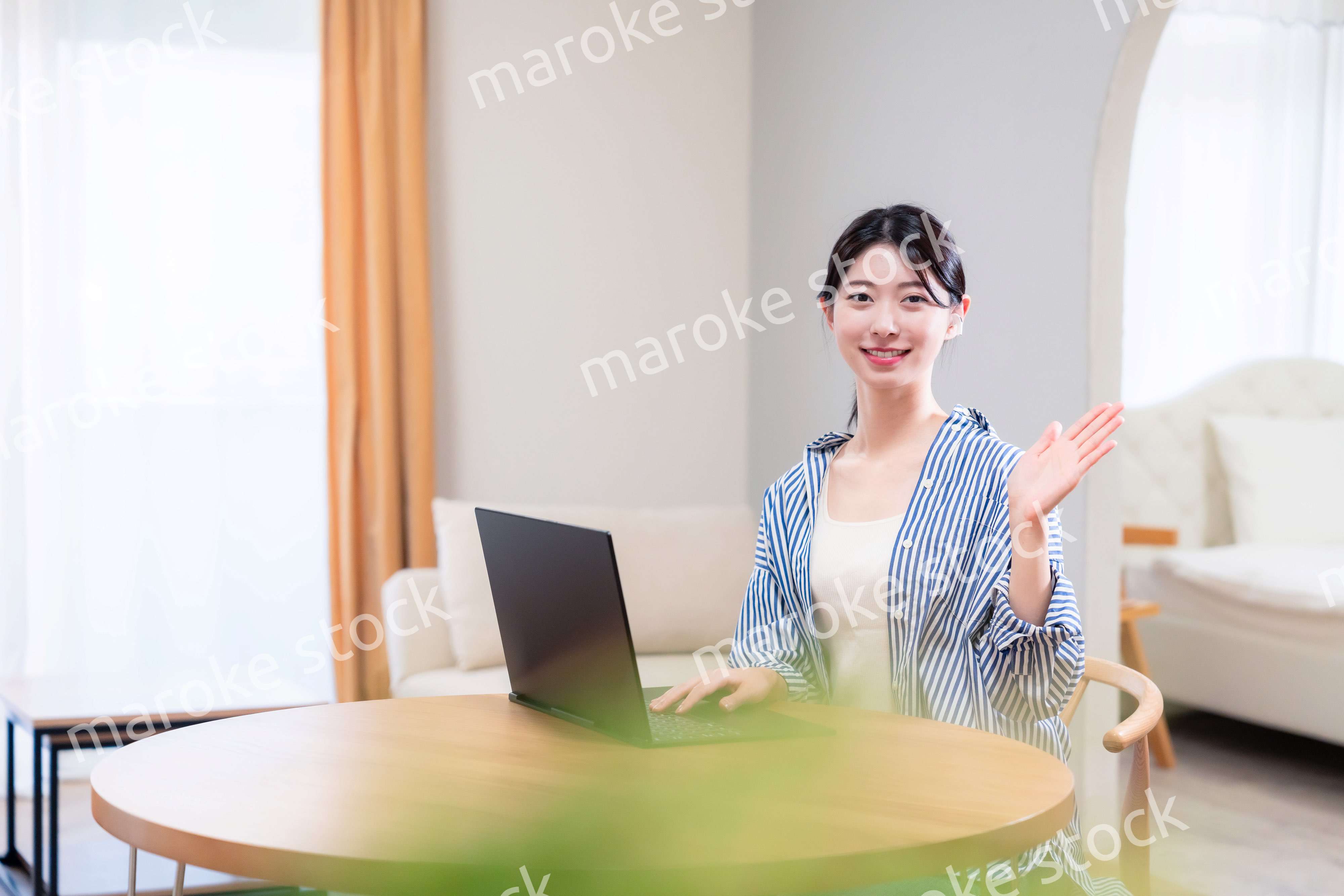 自宅で笑顔でリモート会議に参加する若い女性