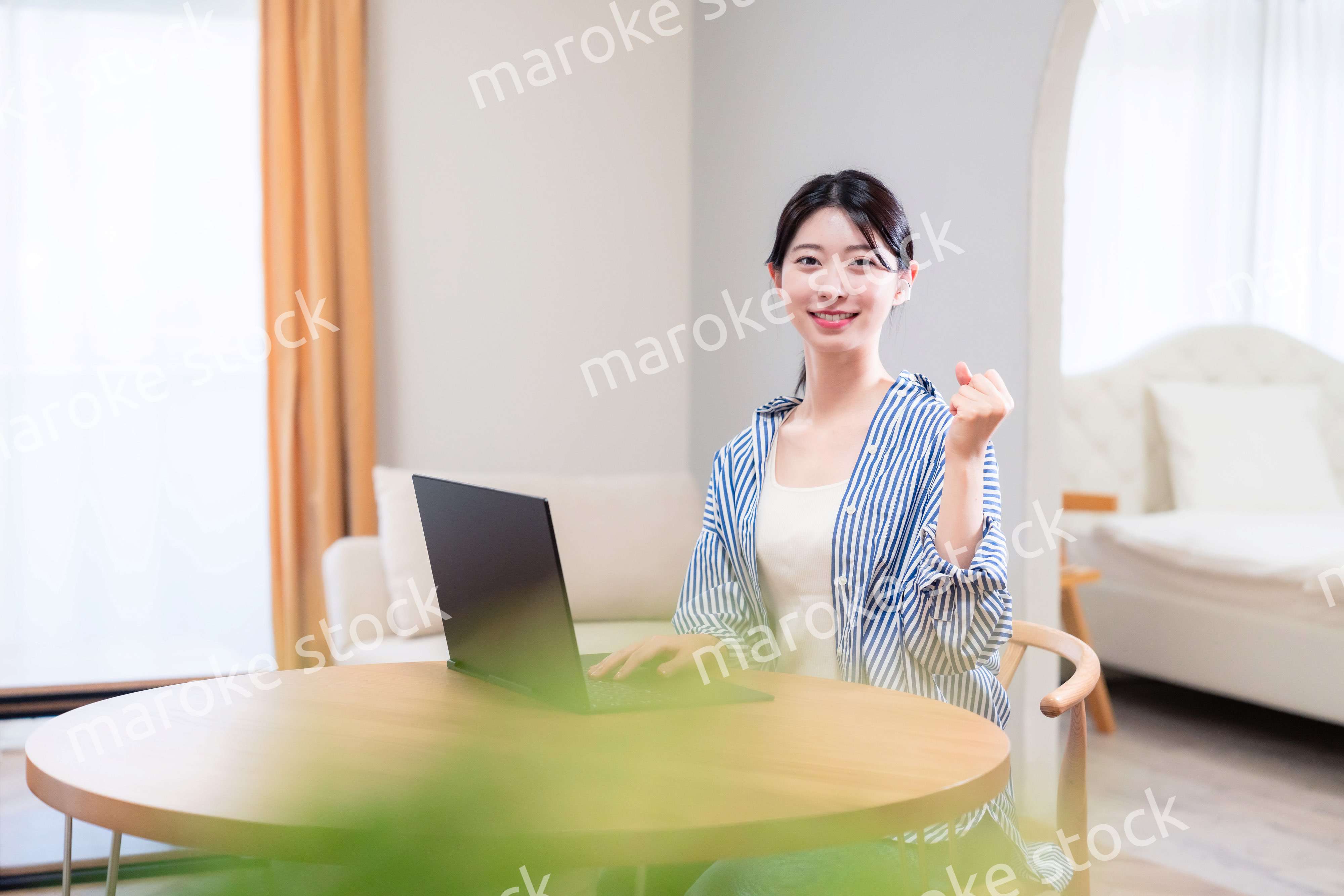 自宅で笑顔でリモート会議に参加する若い女性