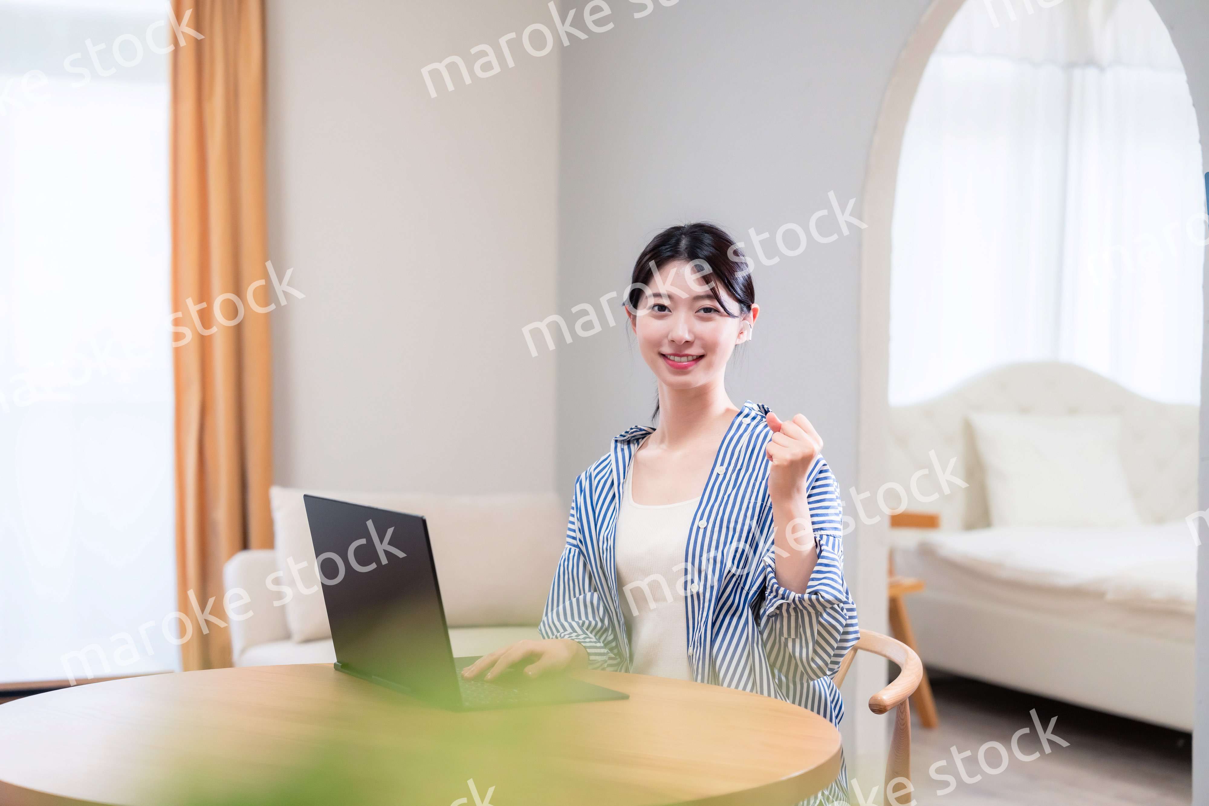 自宅で笑顔でリモート会議に参加する若い女性