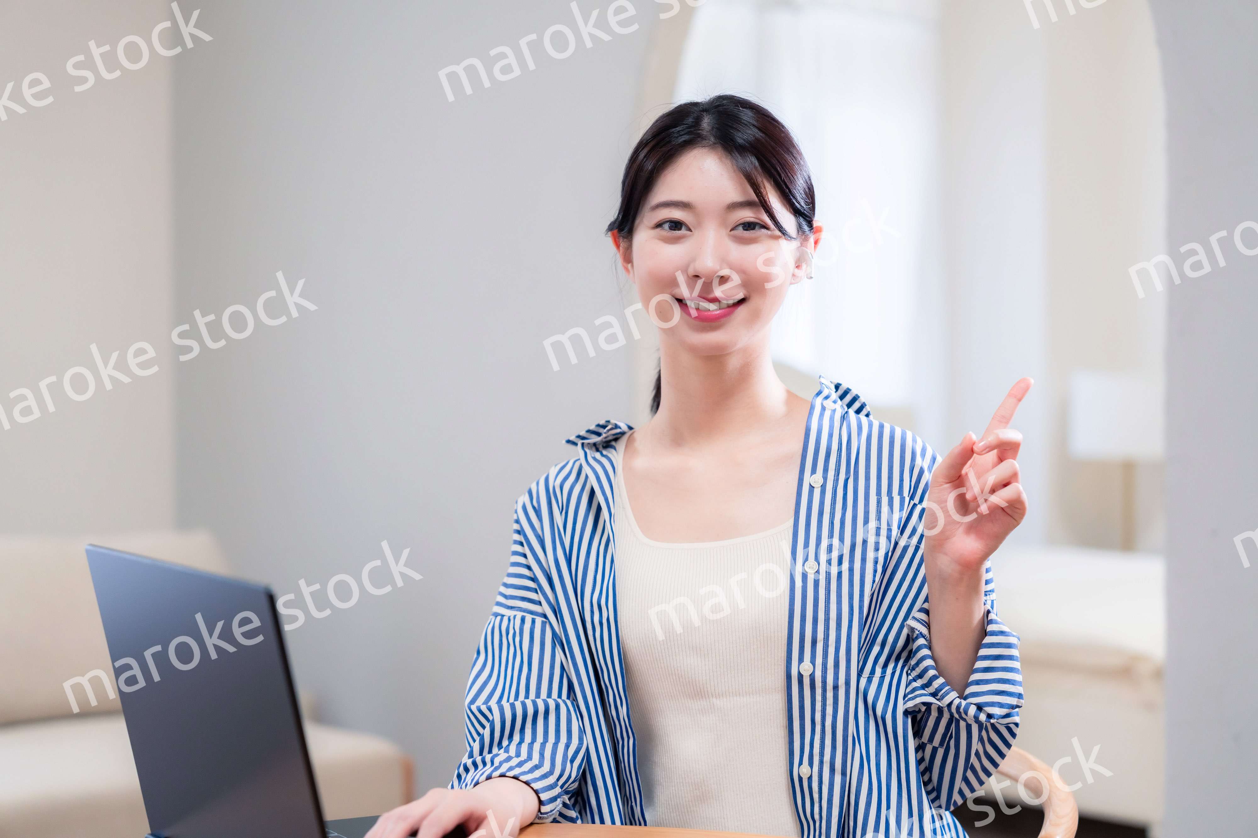 自宅で笑顔でリモート会議に参加する若い女性