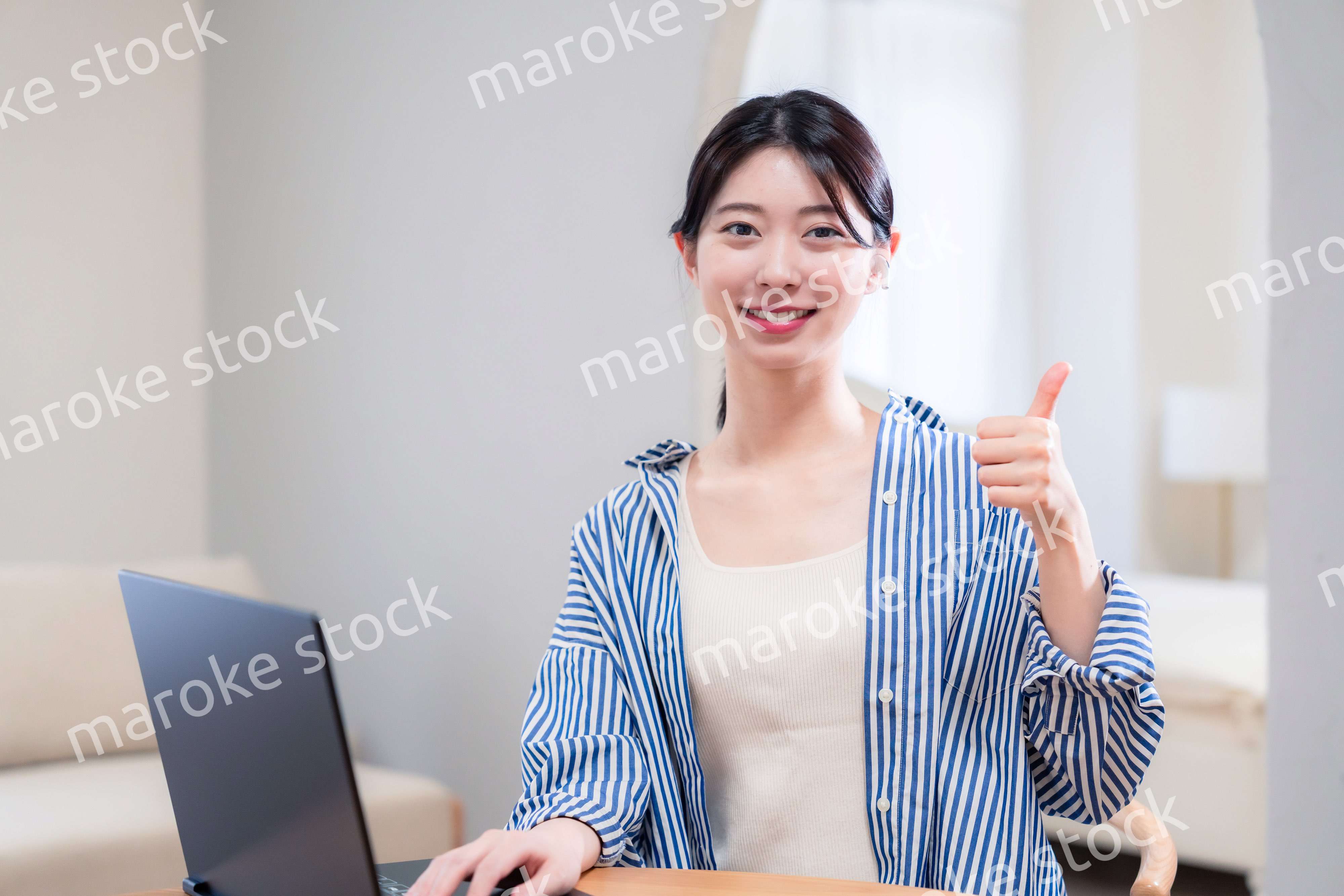 自宅で笑顔でリモート会議に参加する若い女性