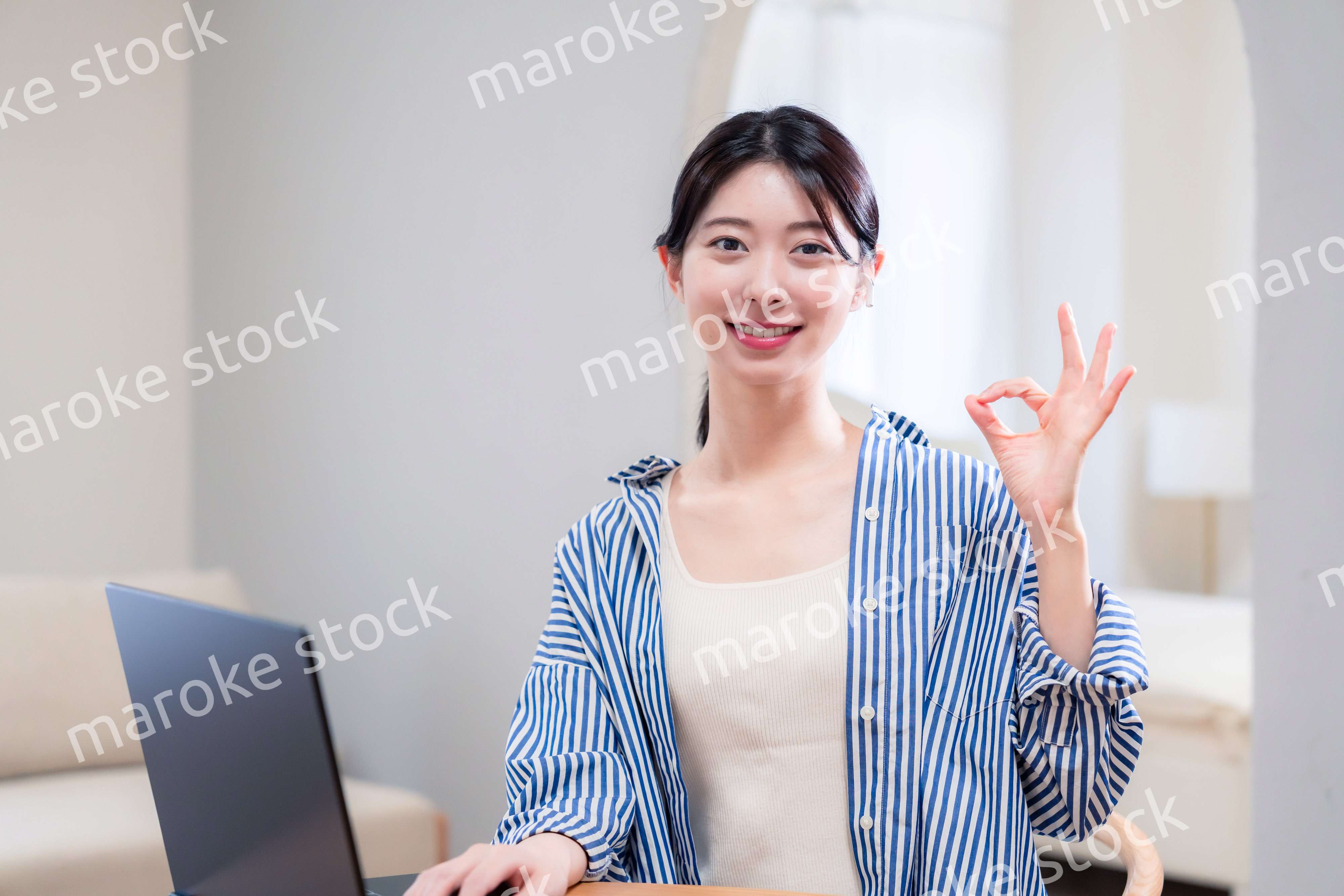 自宅で笑顔でリモート会議に参加する若い女性