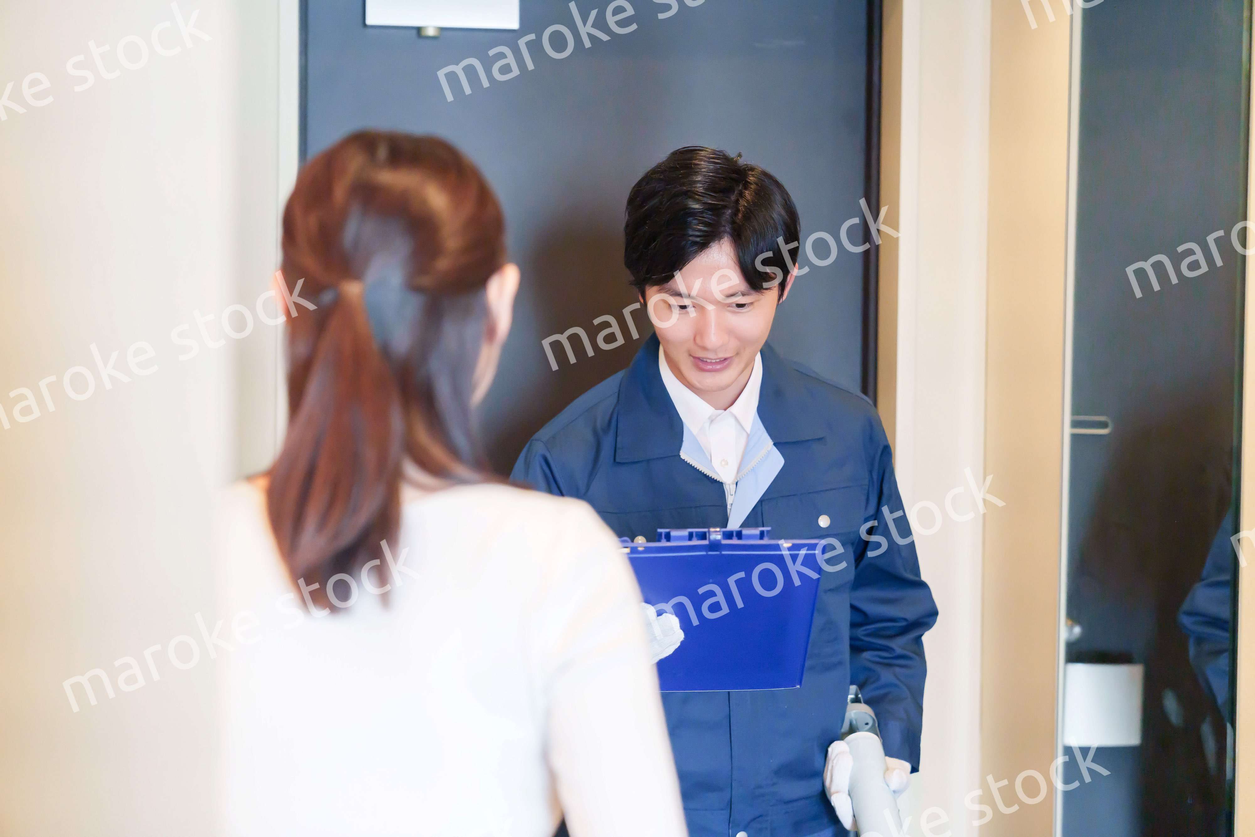 マンションを戸別訪問して点検をする業者の男性