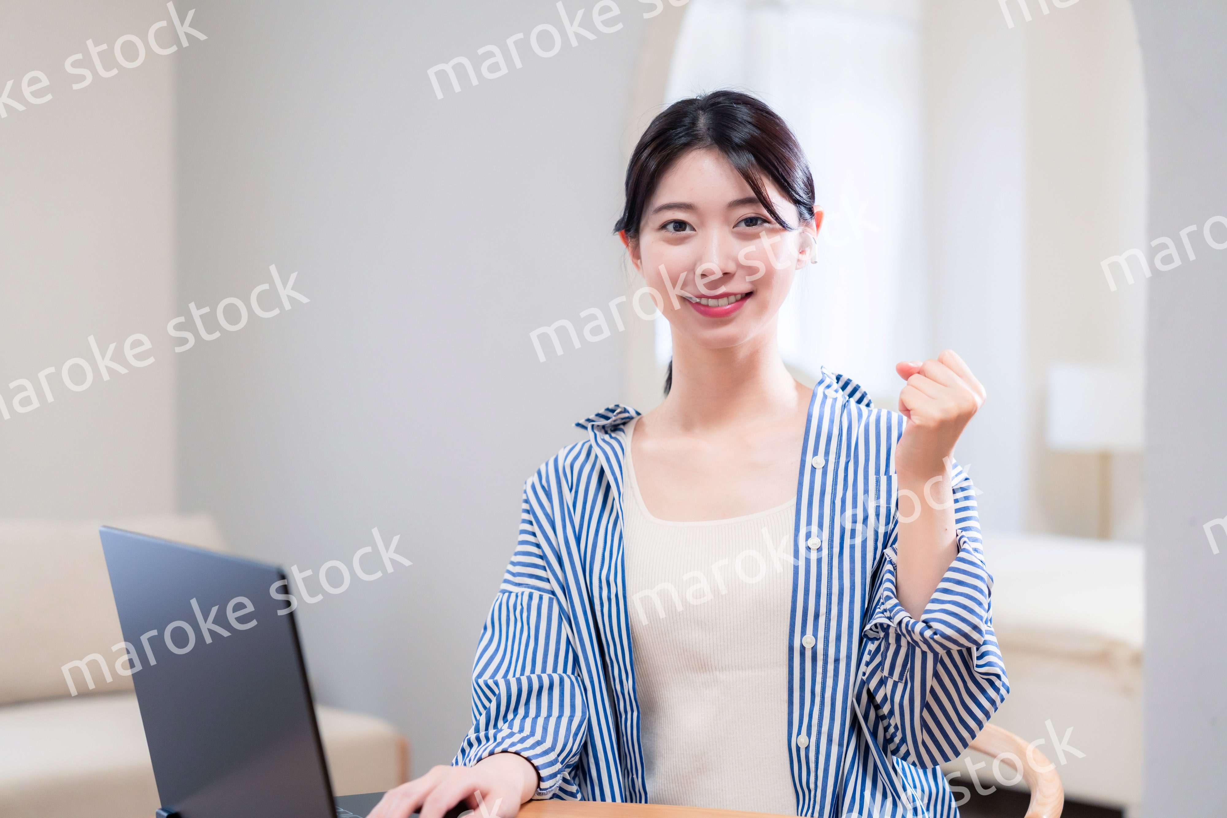 自宅で笑顔でリモート会議に参加する若い女性