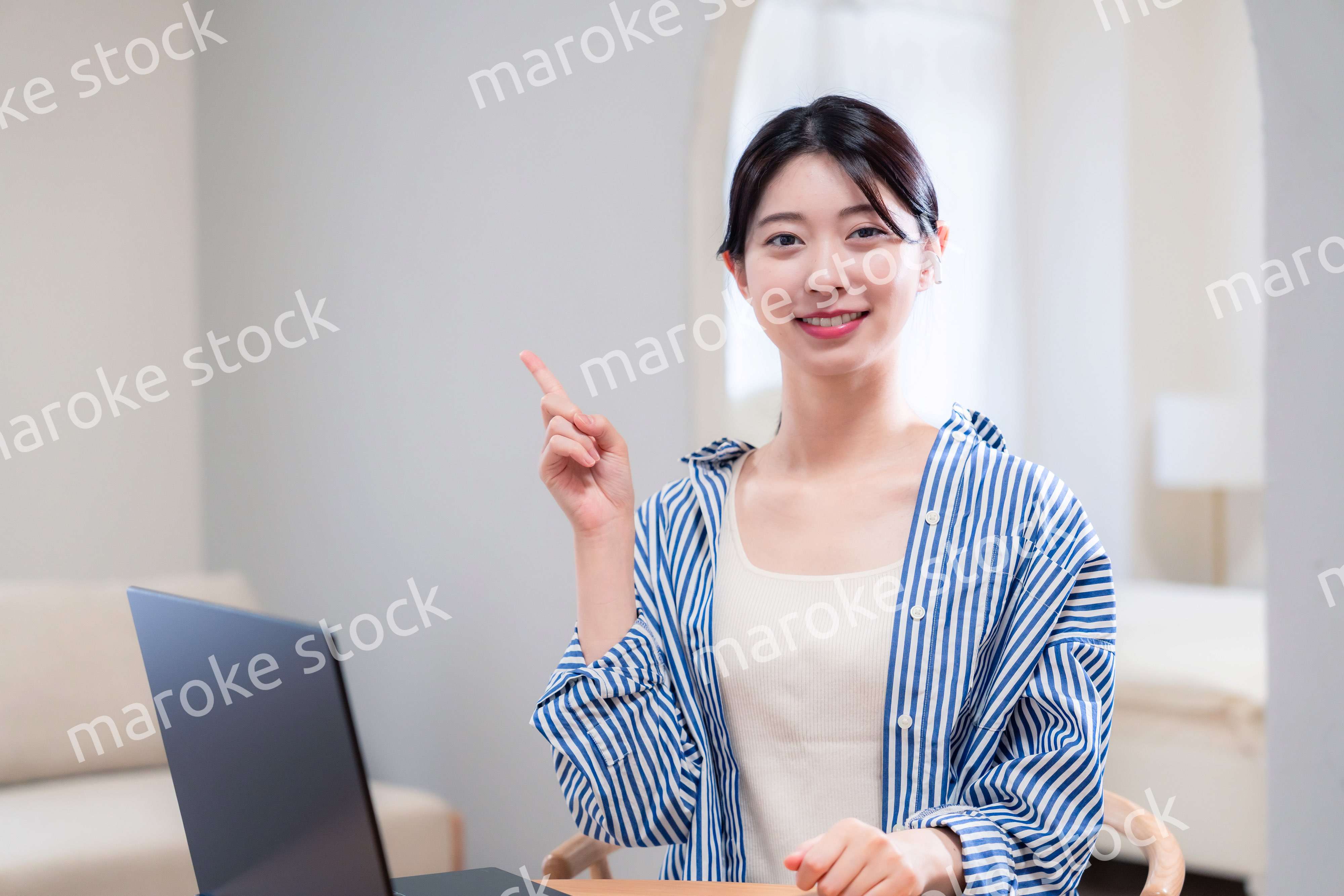 自宅で笑顔でリモート会議に参加する若い女性