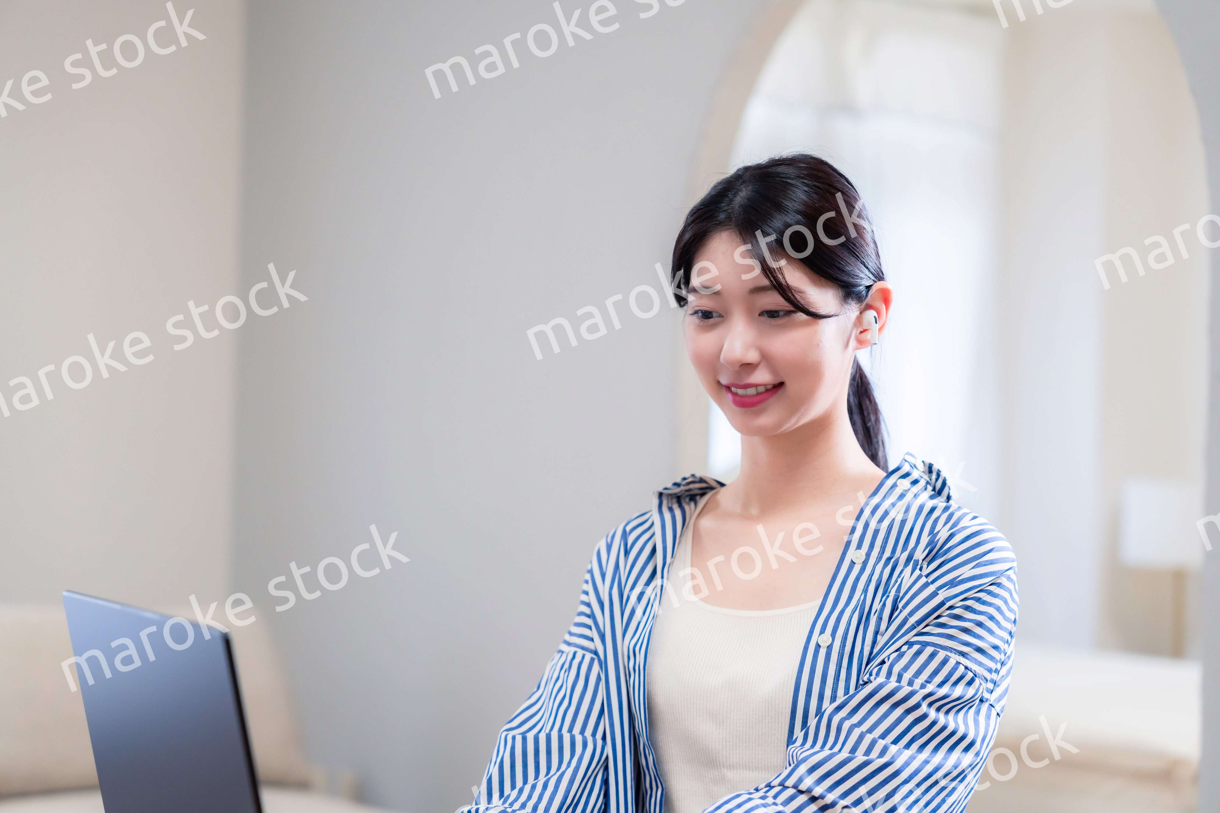 自宅で笑顔でリモート会議に参加する若い女性