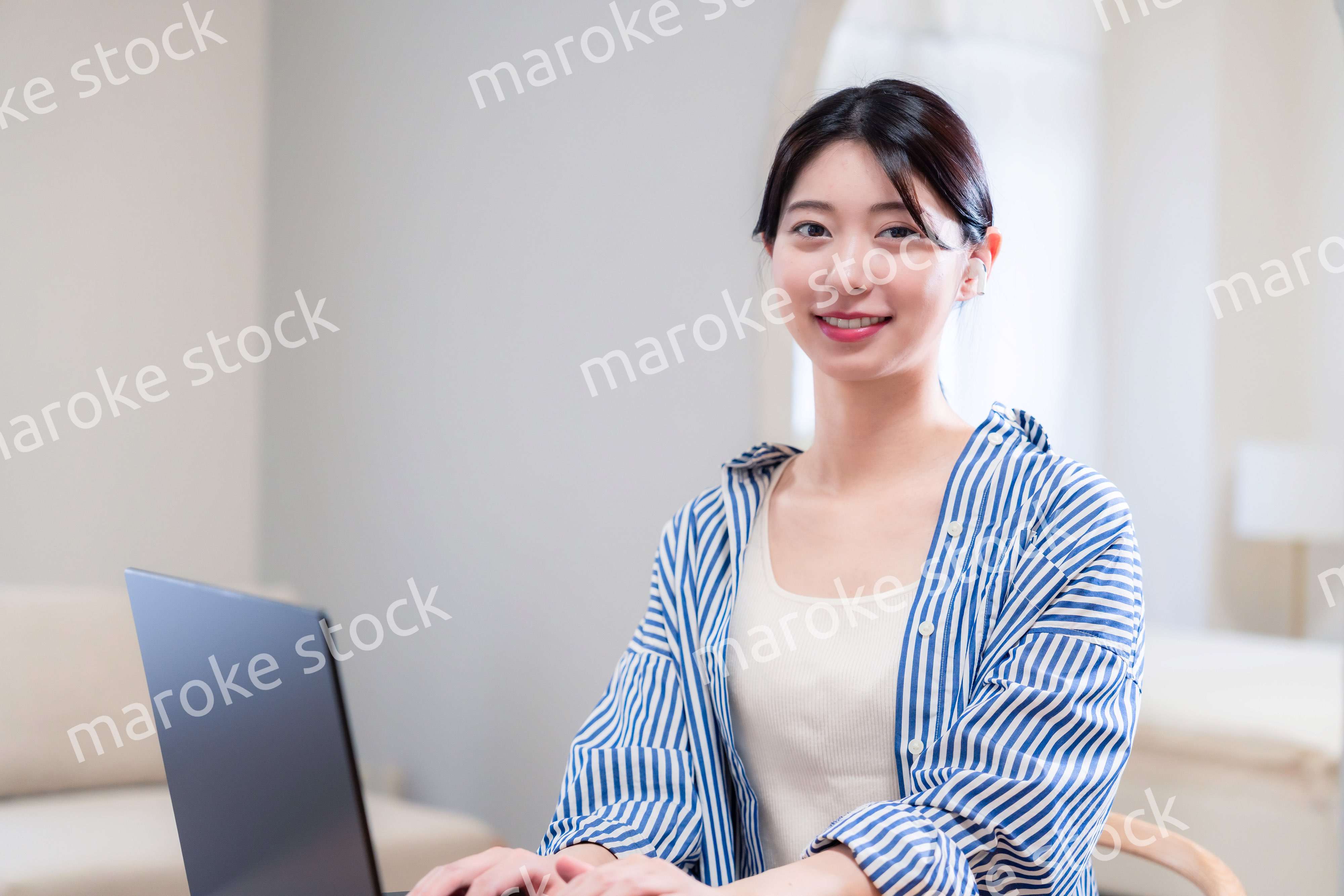 自宅で笑顔でリモート会議に参加する若い女性