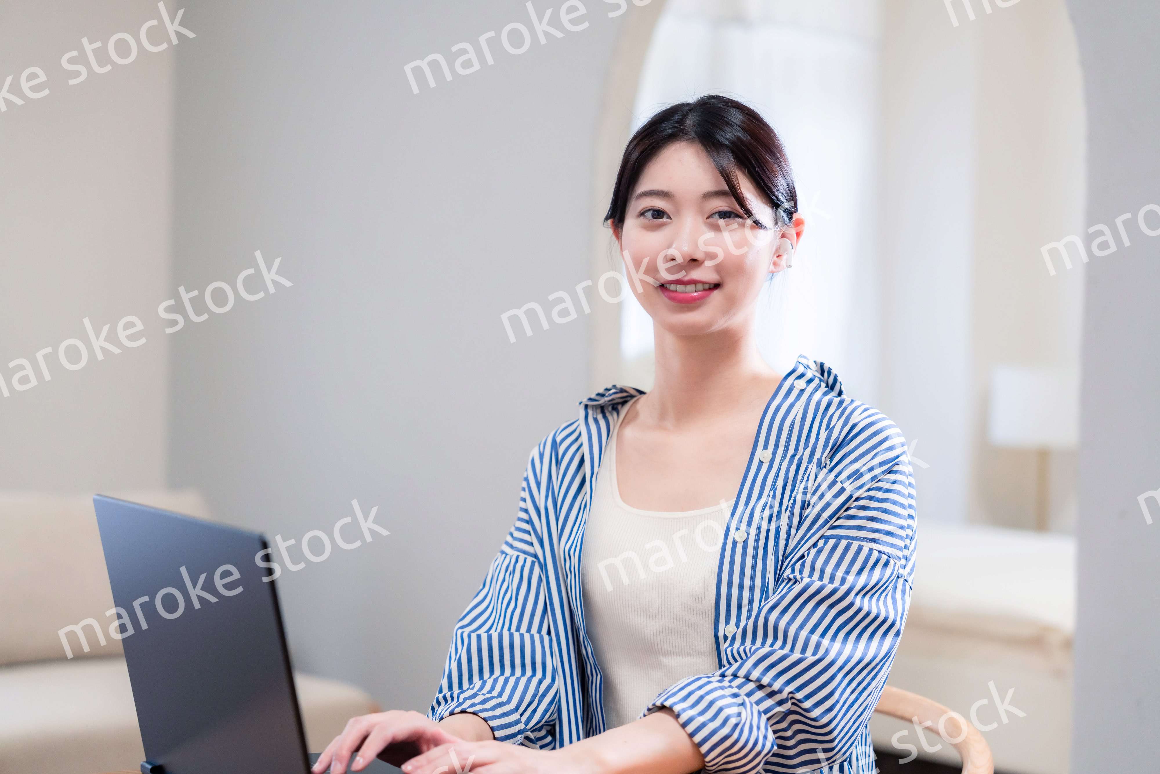 自宅で笑顔でリモート会議に参加する若い女性