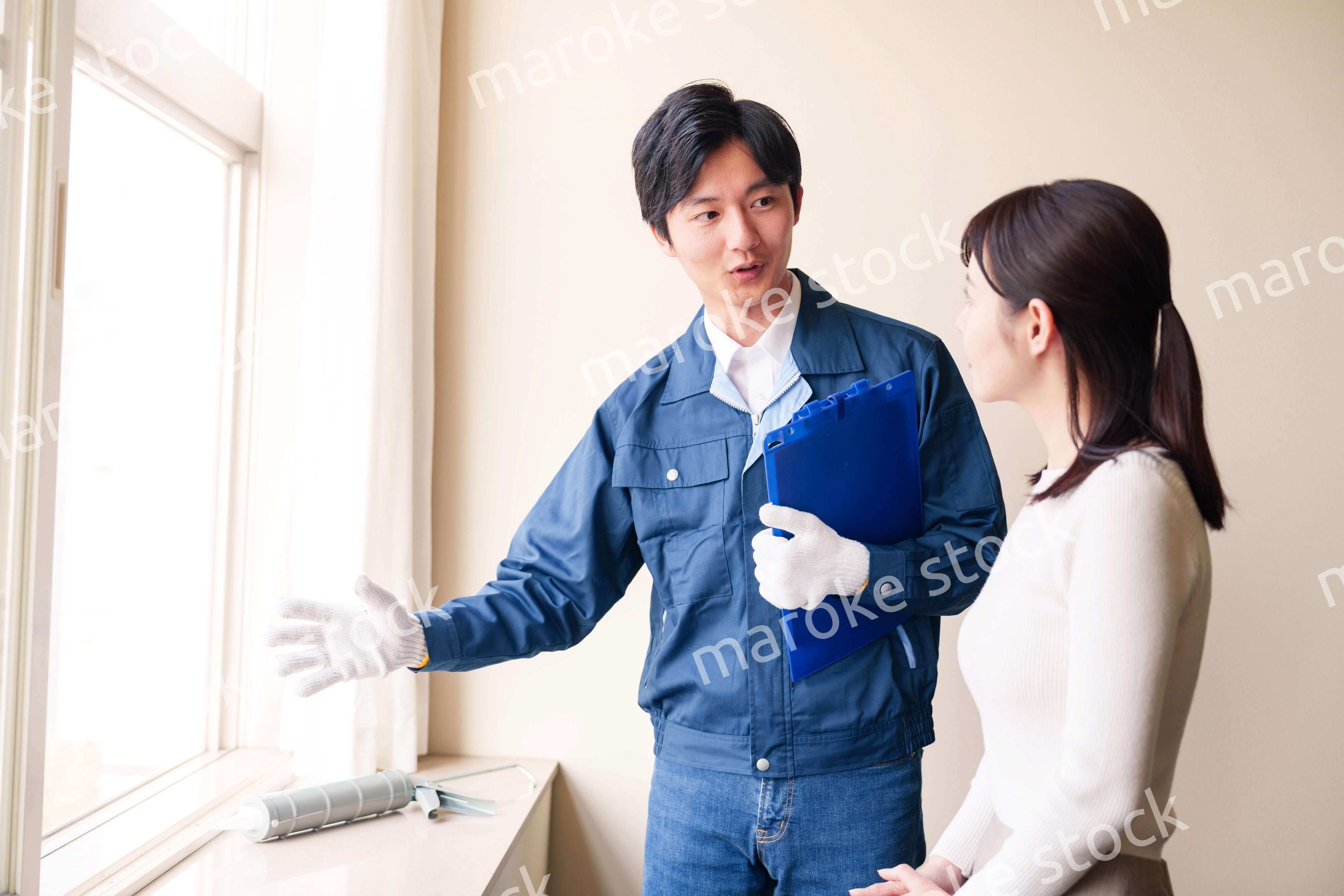 修理業者に家の修理をお願いする女性