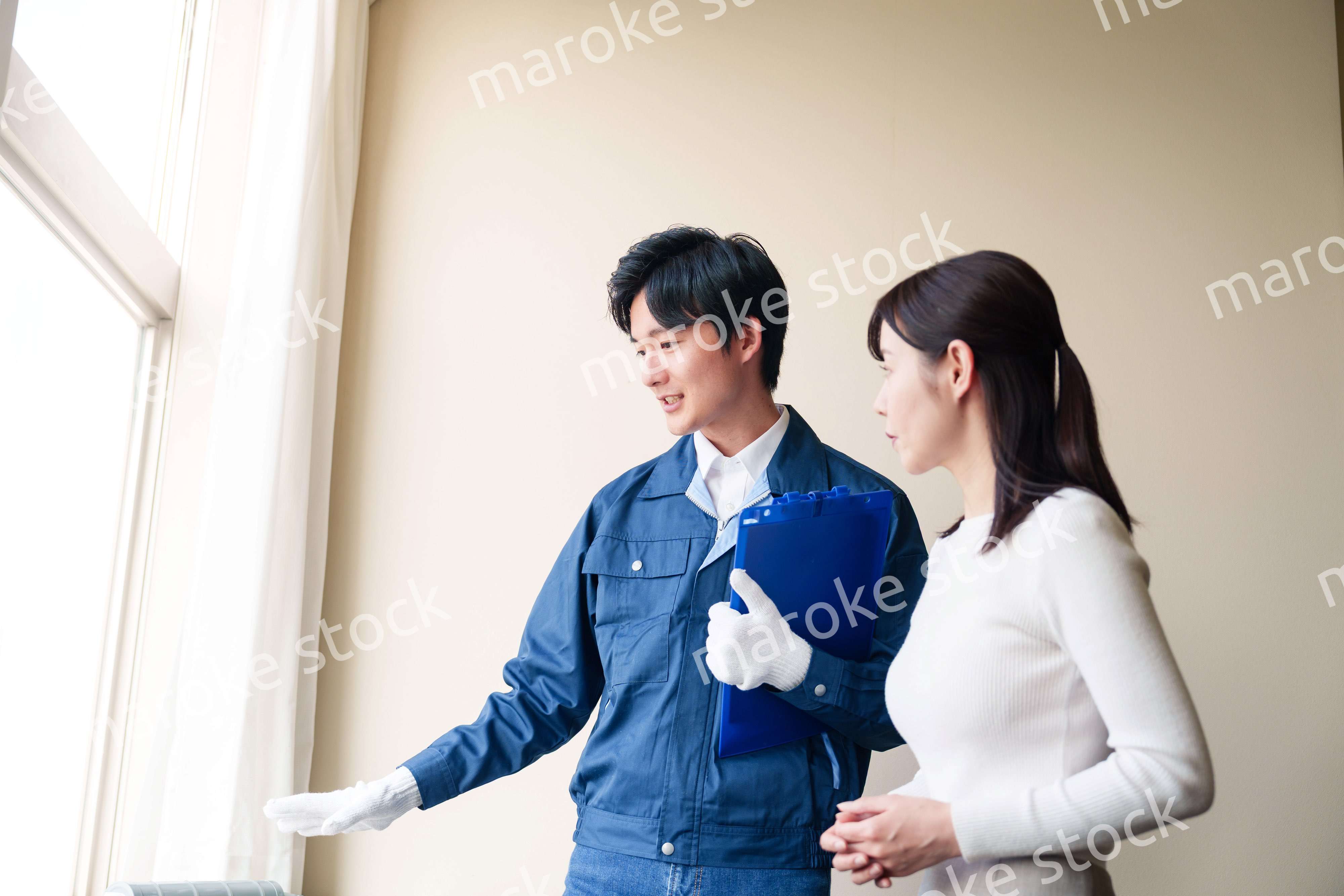 修理業者に家の修理をお願いする女性