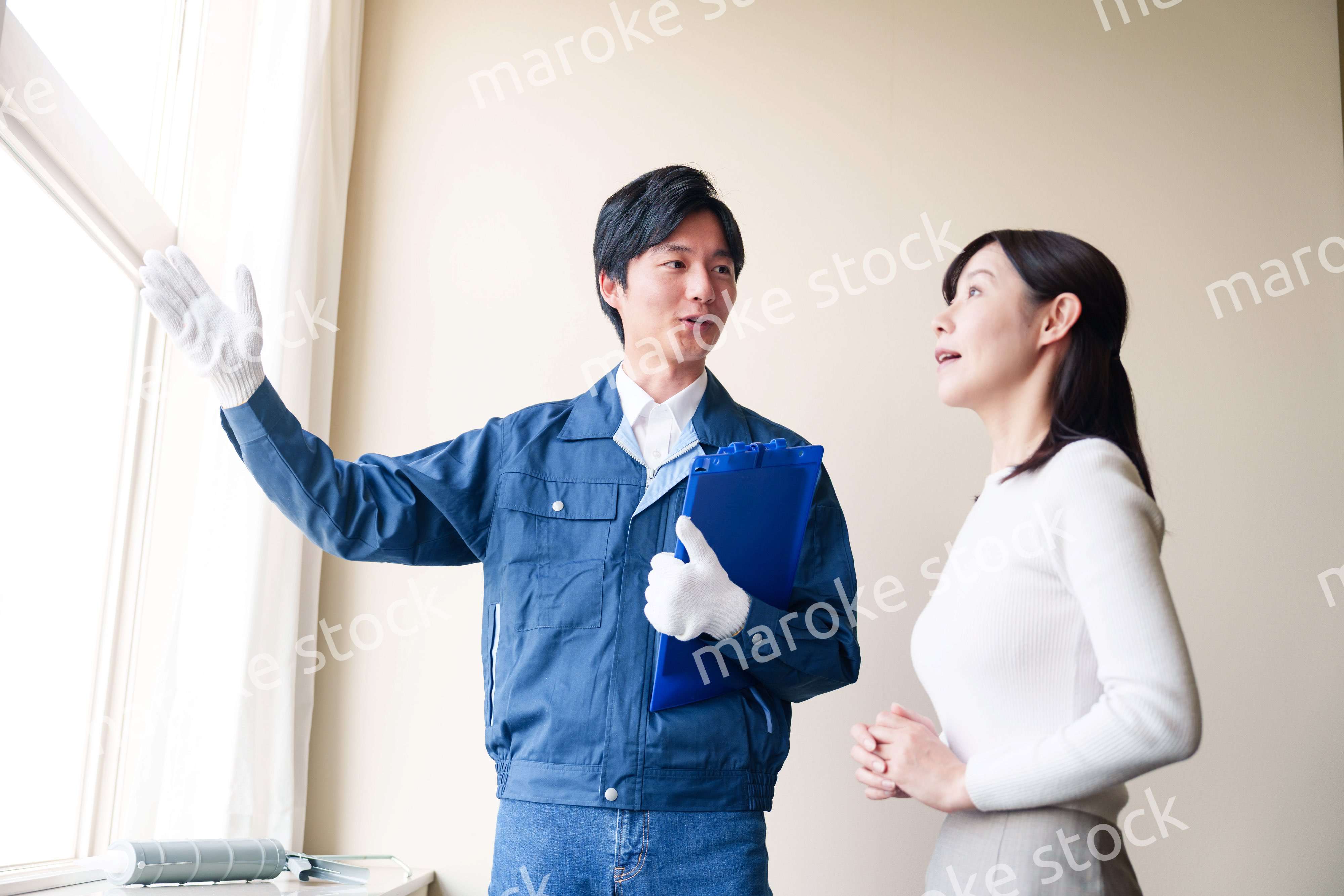 修理業者に家の修理をお願いする女性