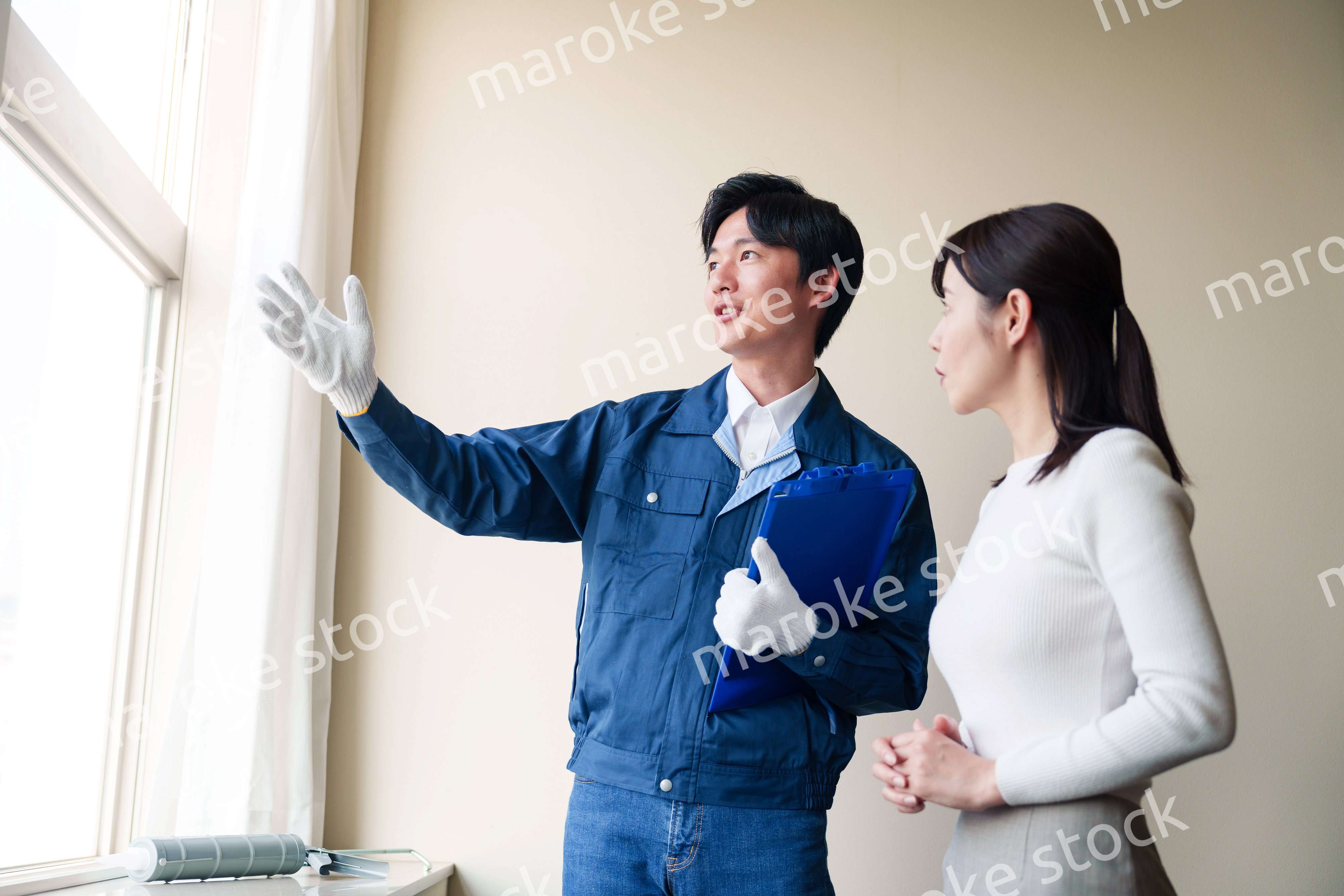 修理業者に家の修理をお願いする女性