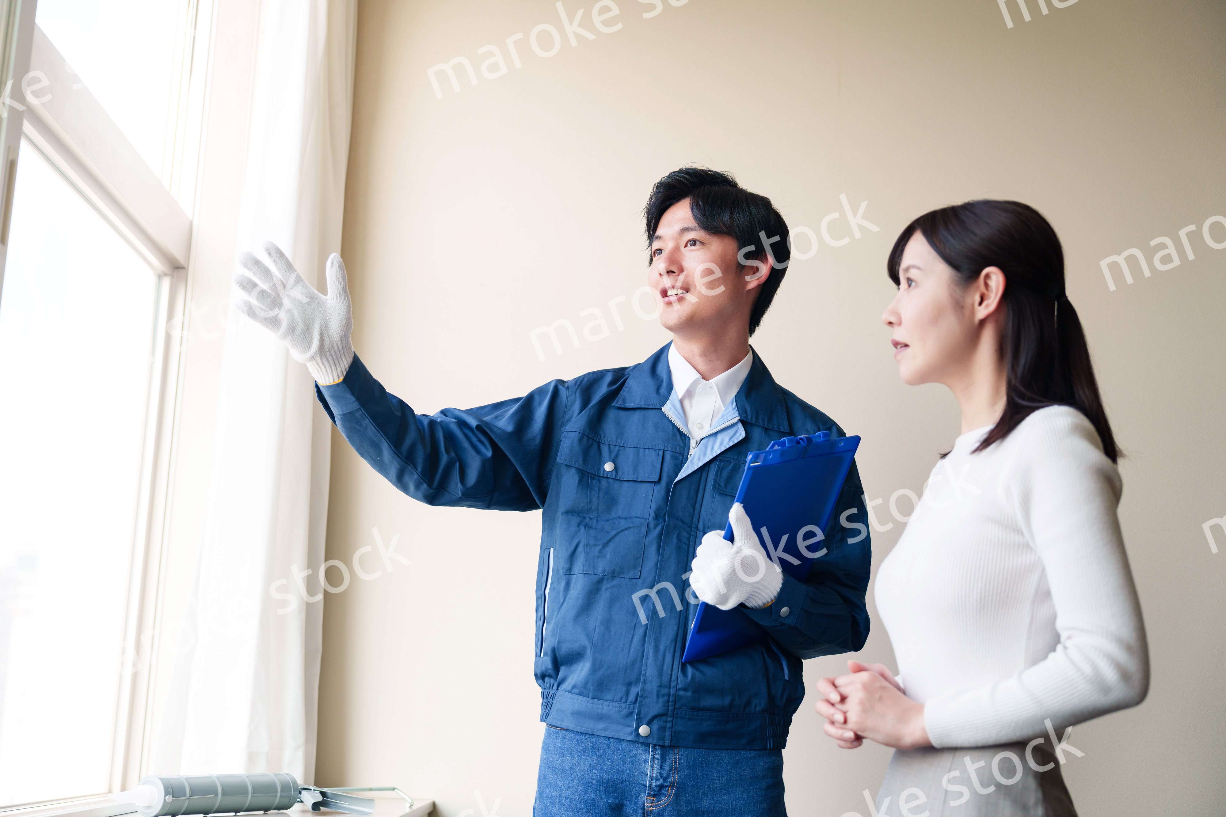 修理業者に家の修理をお願いする女性