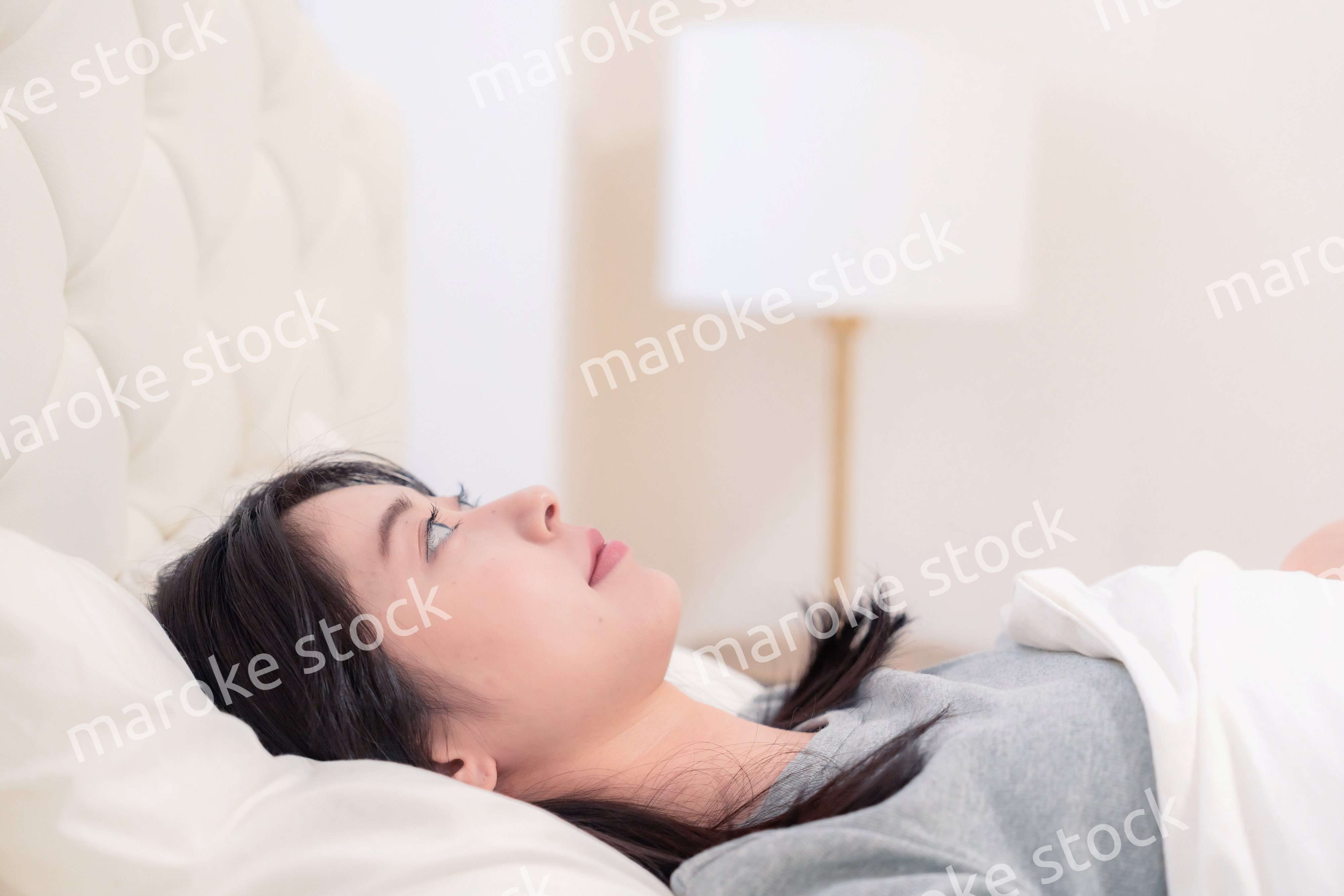 ベッドで寝る若い女性