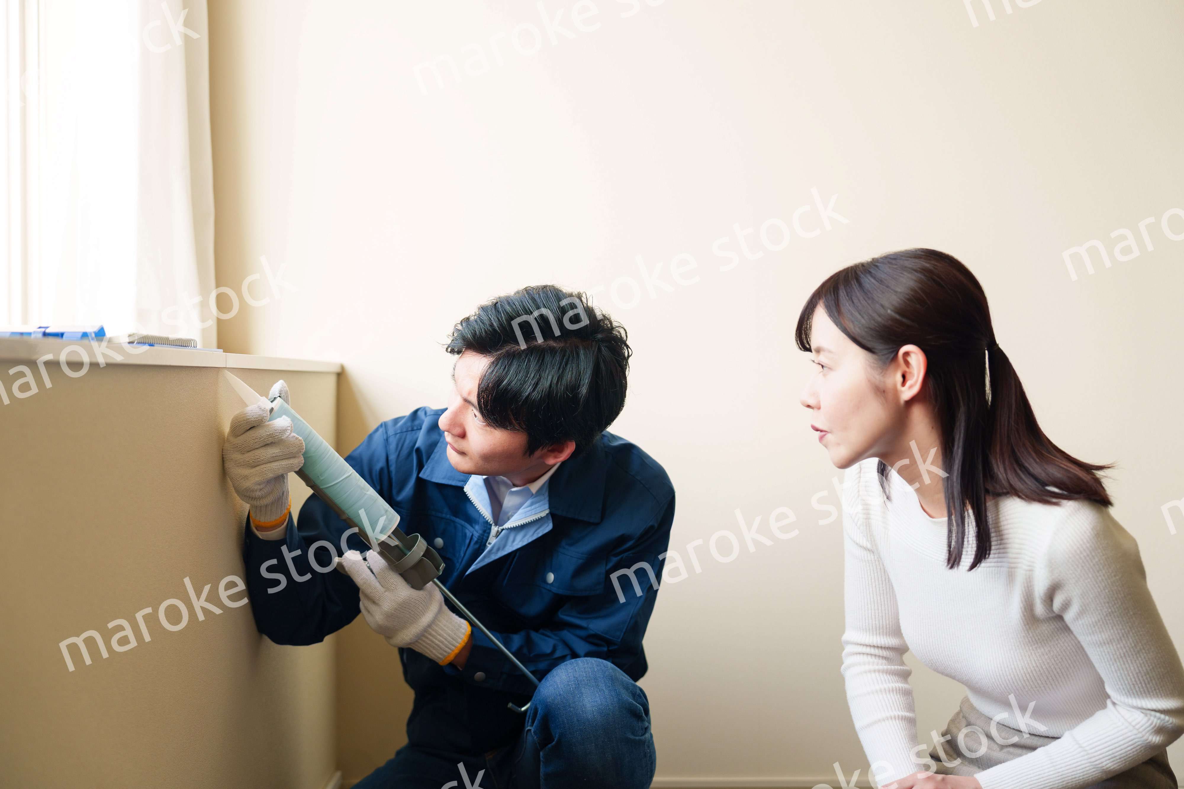 修理業者に家の修理をお願いする女性