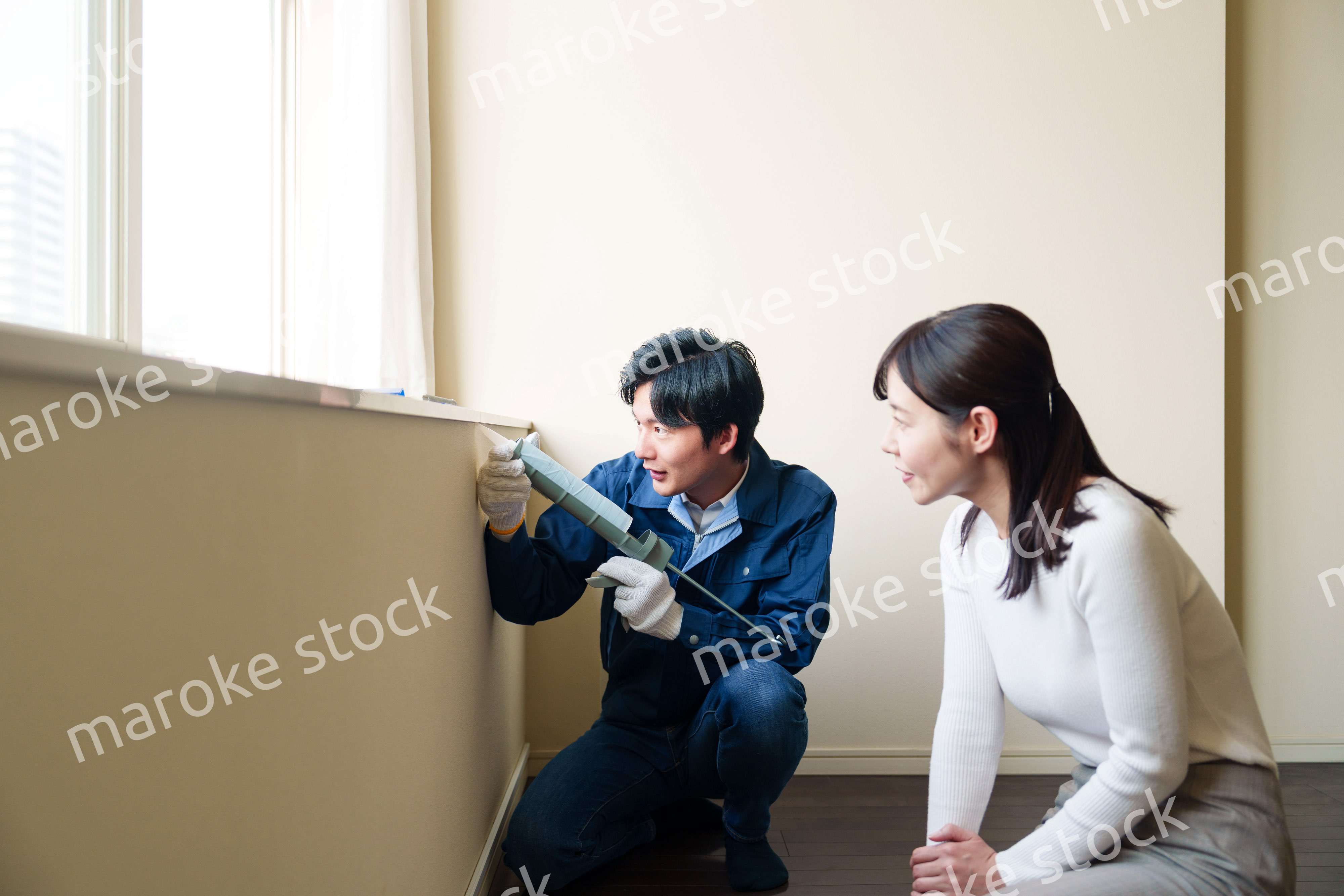 修理業者に家の修理をお願いする女性