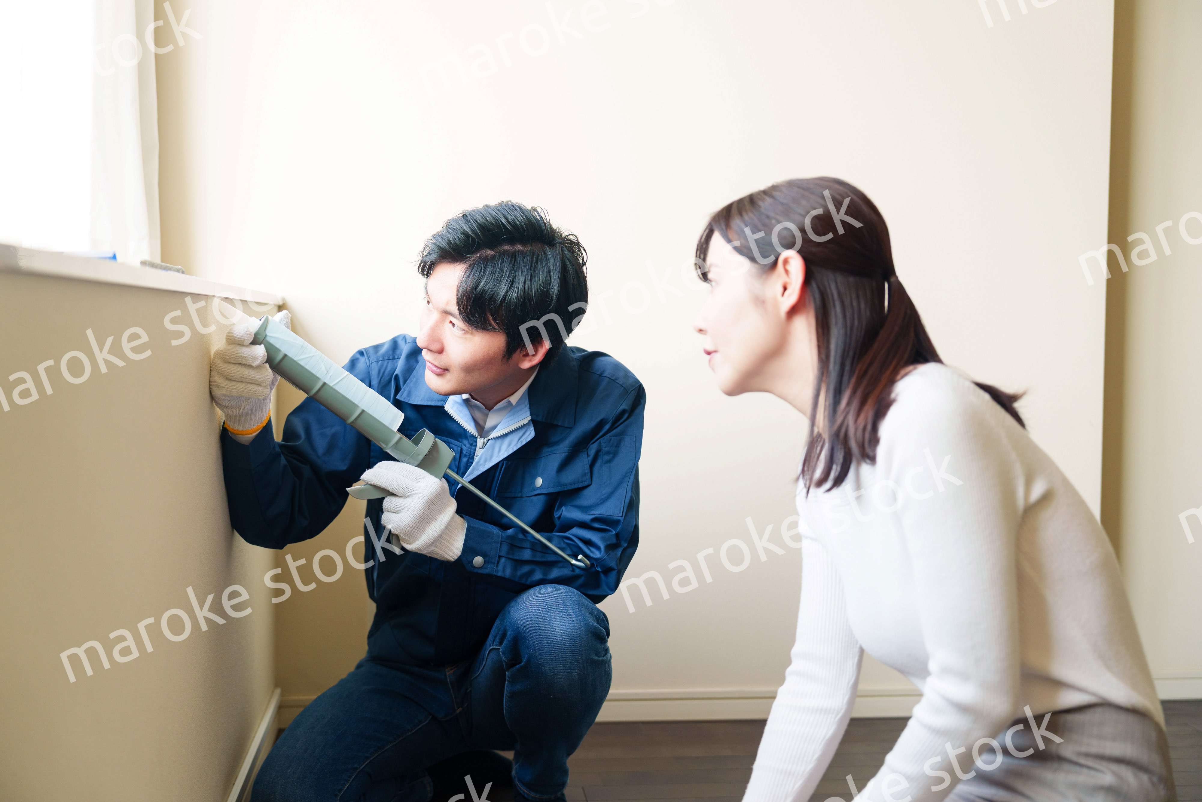 修理業者に家の修理をお願いする女性