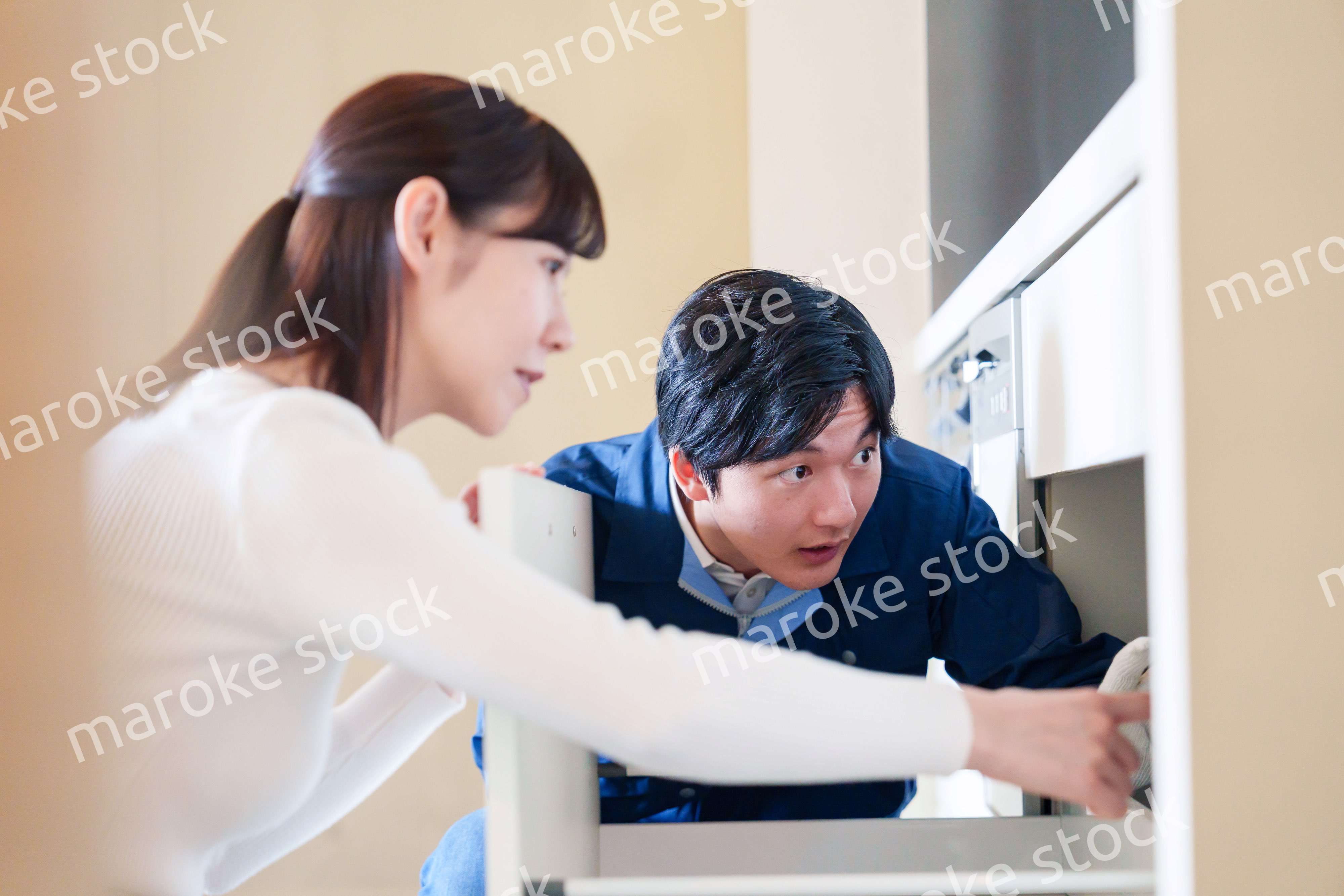 修理業者に家の修理をお願いする女性