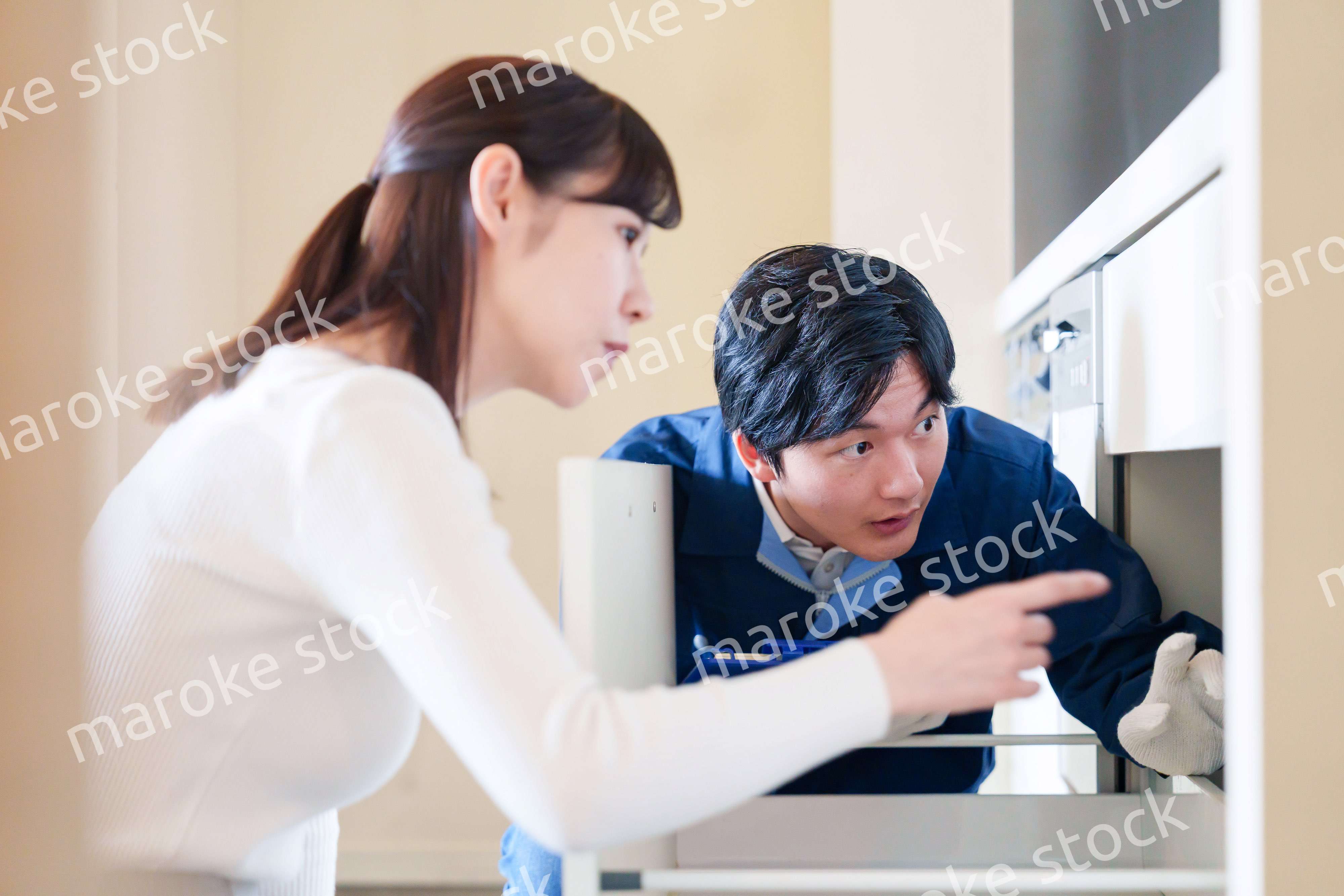 修理業者に家の修理をお願いする女性