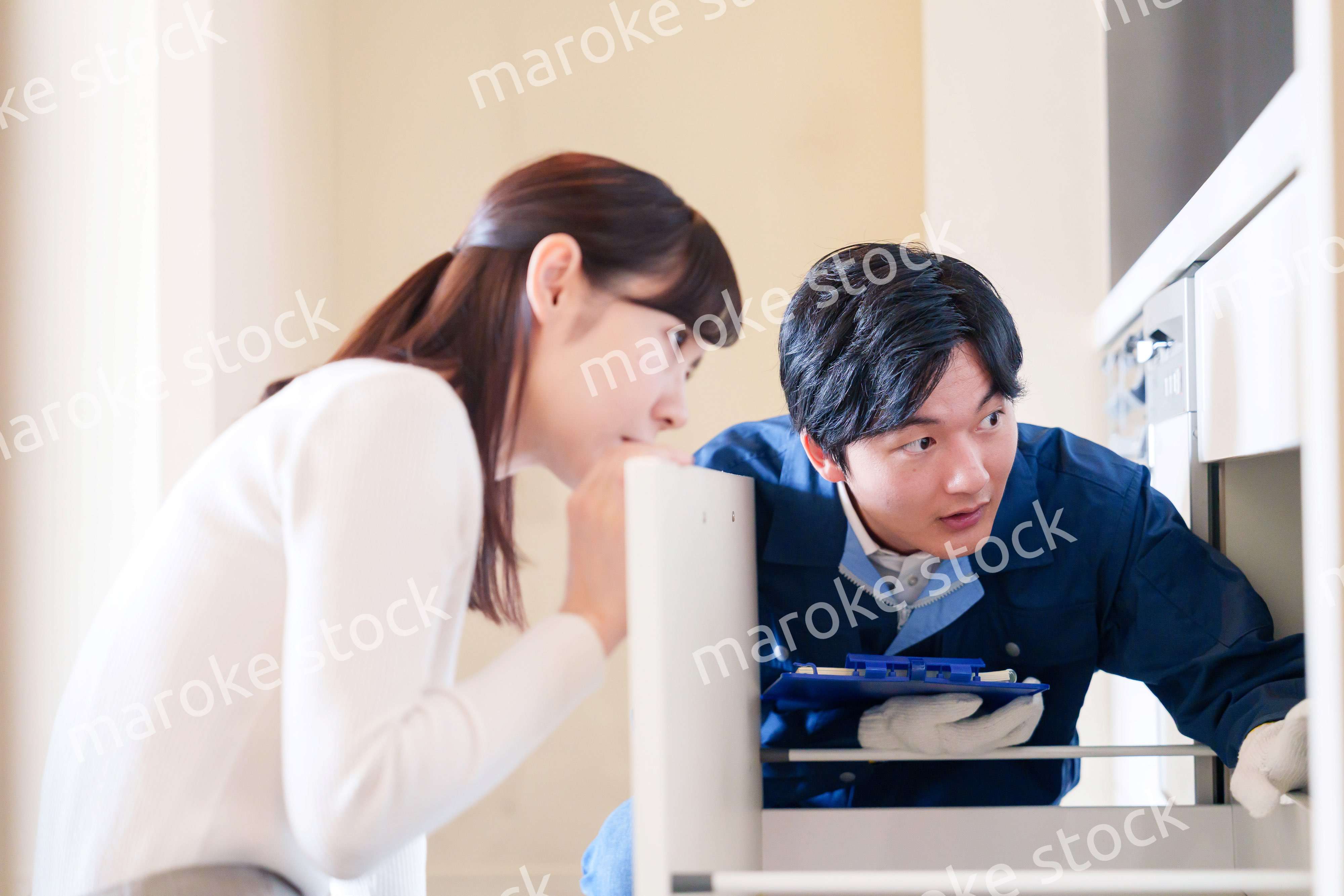 修理業者に家の修理をお願いする女性